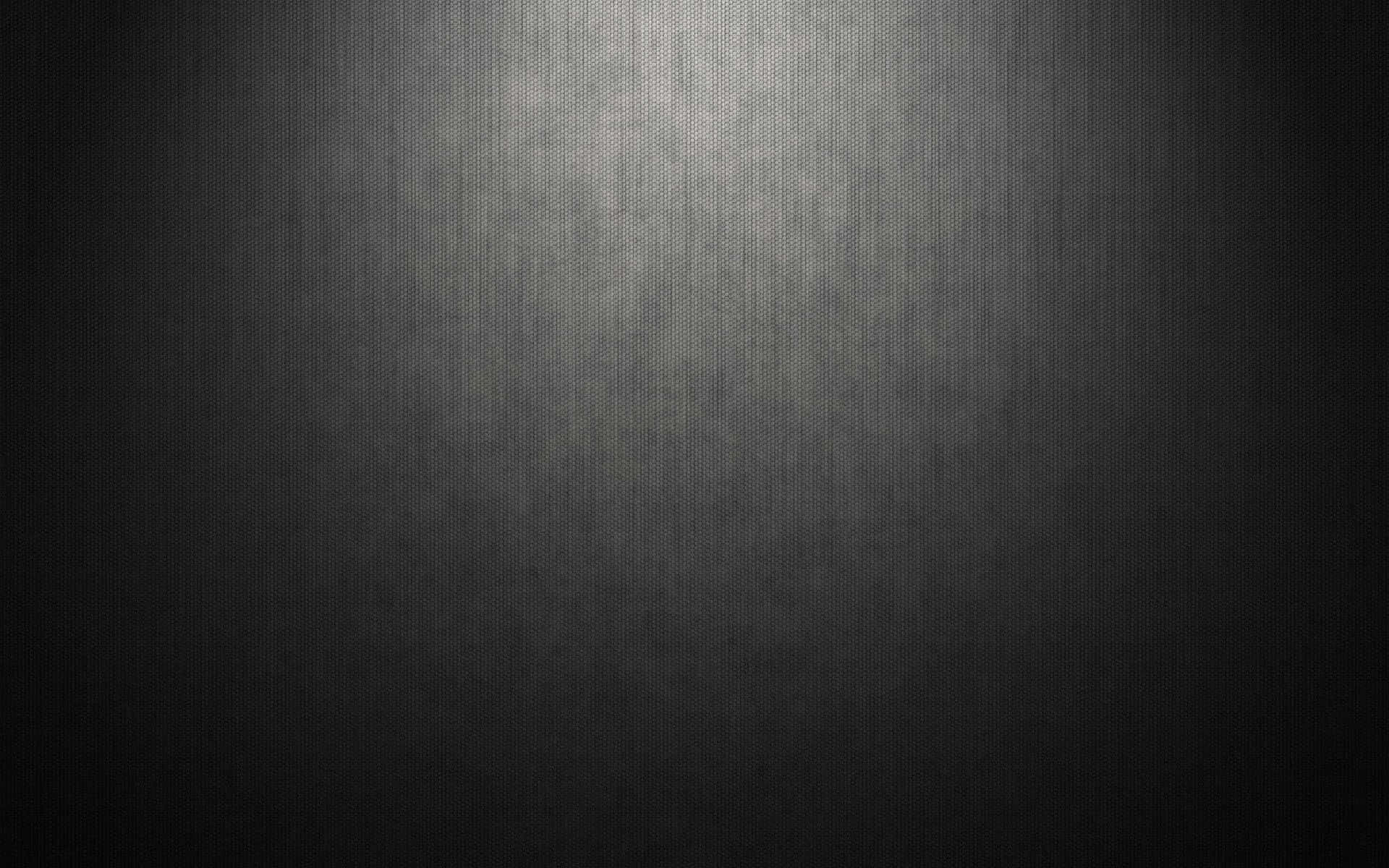 Grey Texture 桌布 壁紙 — 一個深色紋理表面，帶有從中心向邊緣漸變淡出的柔和聚光燈效果。