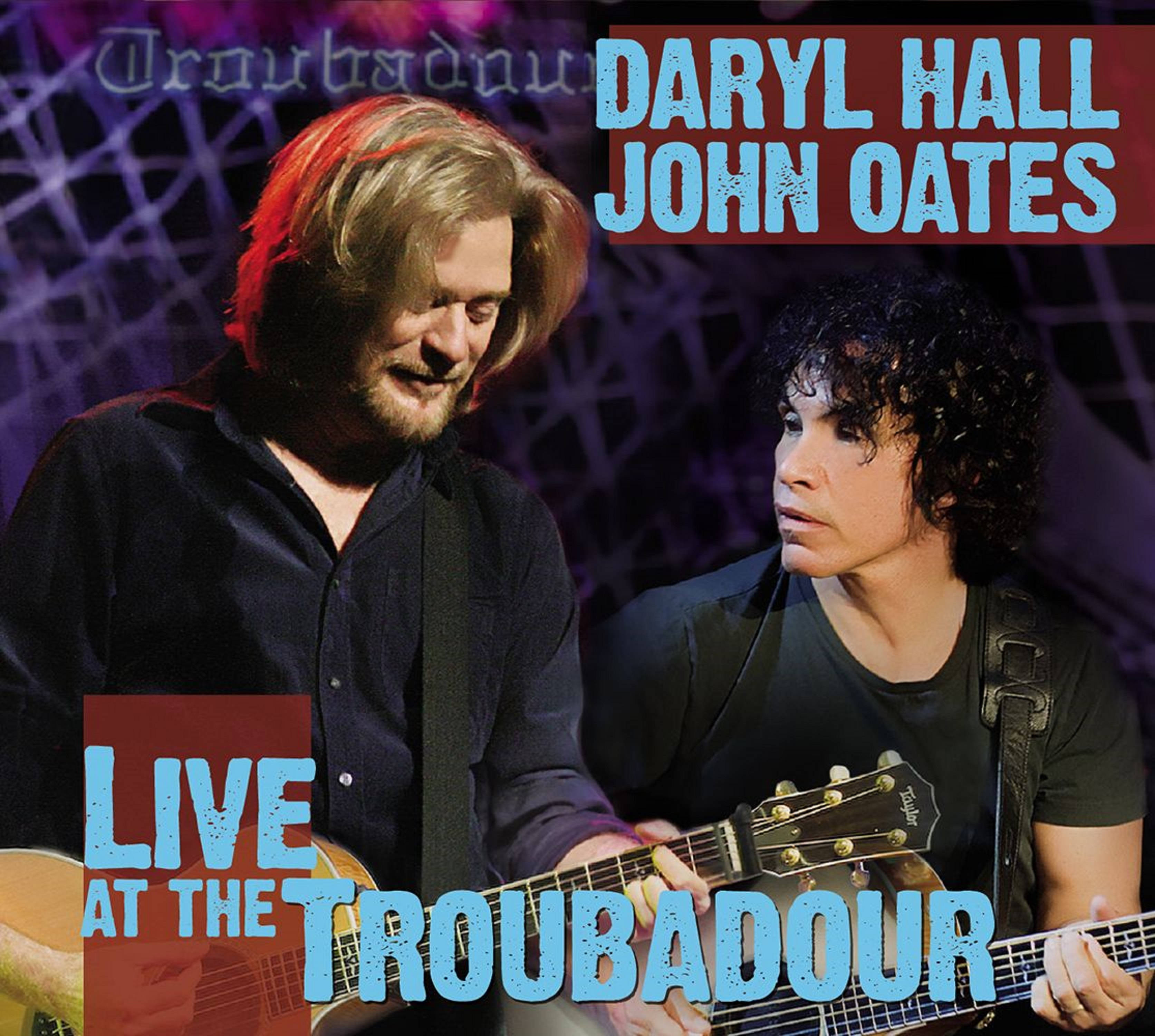 音樂 桌布 壁紙 — Daryl Hall 和 John Oates 在充滿活力的紫色和紅色舞台燈光下，帶著吉他進行現場表演。