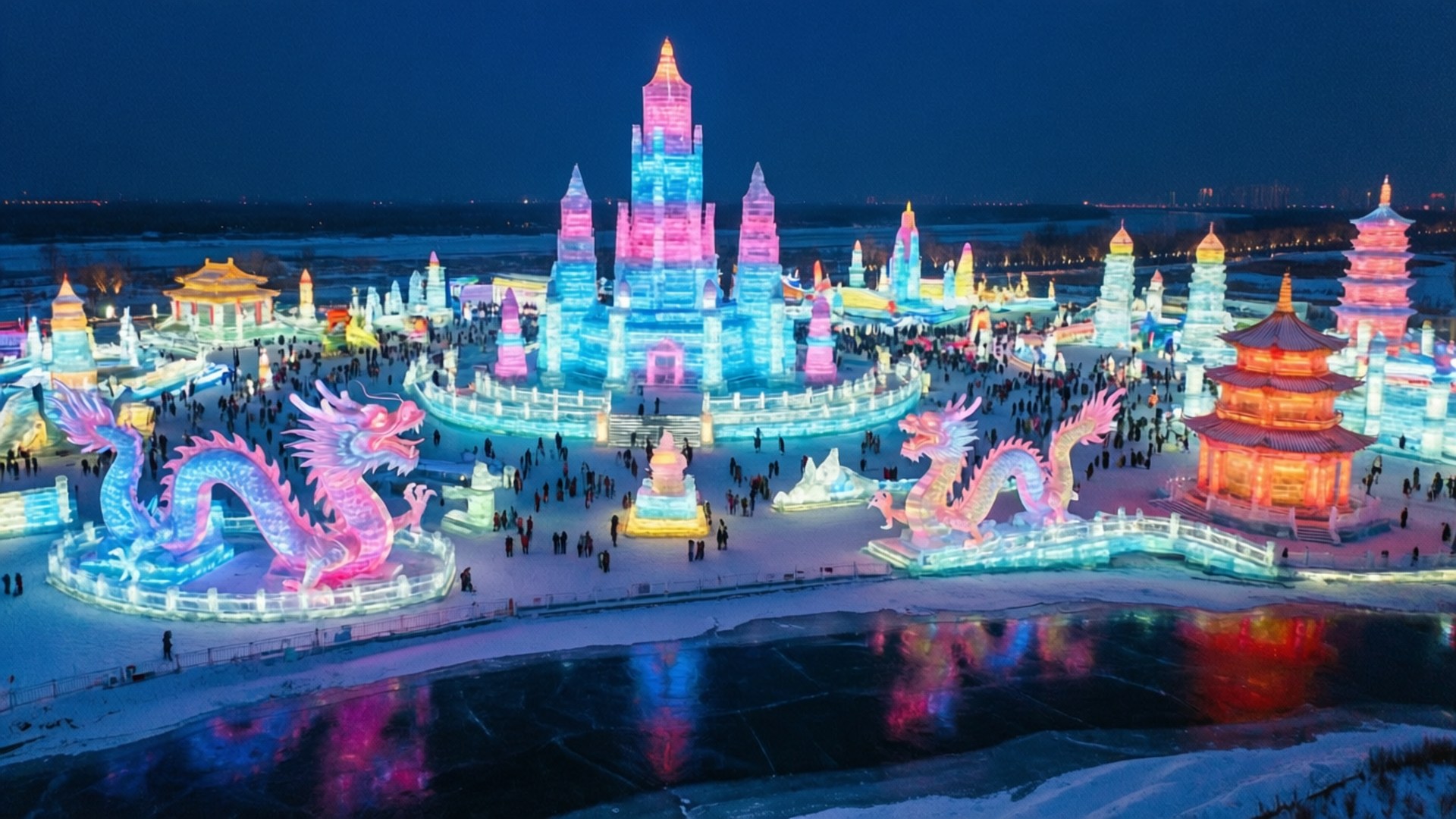 Neon Ice Kingdom 壁紙 — 一個令人眼花繚亂的夜間冰雕節，展示發光的粉紅色、藍色和橙色冰雕，包括龍和寶塔，人群在其中行走。