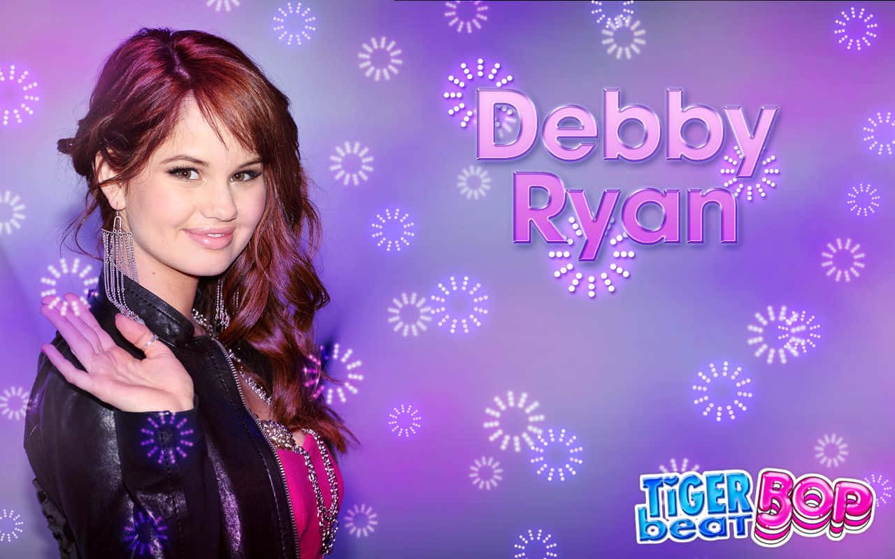 debby ryan 桌布 壁紙 — Debby Ryan 穿著黑色皮外套，在充滿活力的紫色背景上，伴隨著閃爍的煙火和粉紅色文字顯示她的名字，溫暖地微笑。