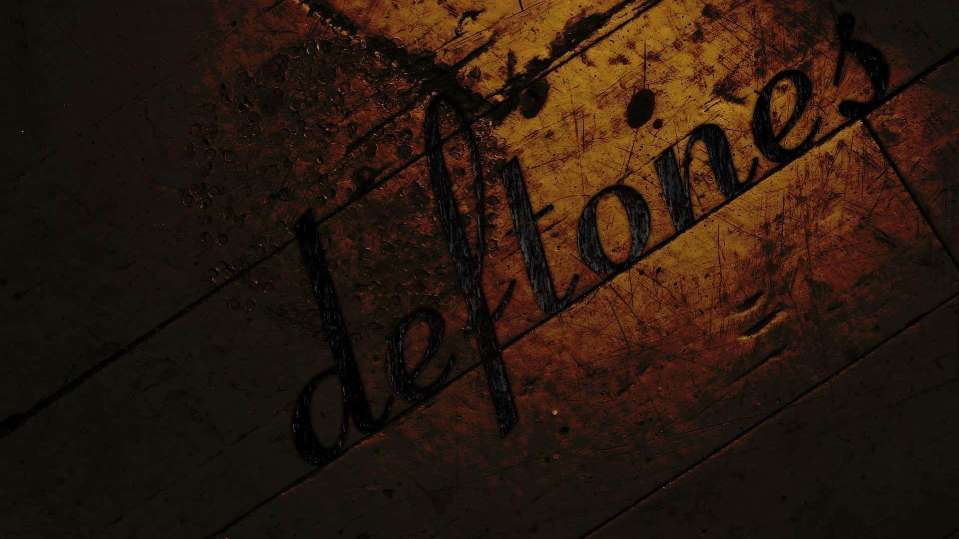桌布 壁紙 — 「deftones」這個字以黑色刮痕出現在經風化的木質表面上，伴隨溫暖的橙色燈光。