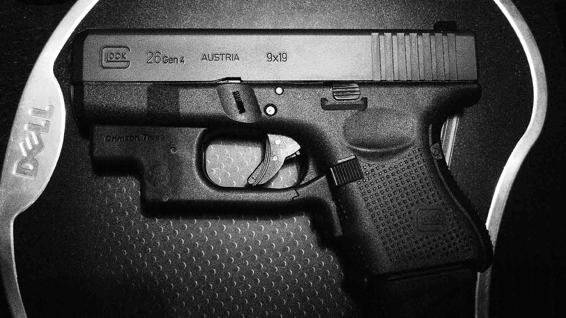 克拉克 桌布 壁紙 — Dell 筆記型電腦保護套內放置的 Glock 26 Gen 4 手槍黑白特寫。