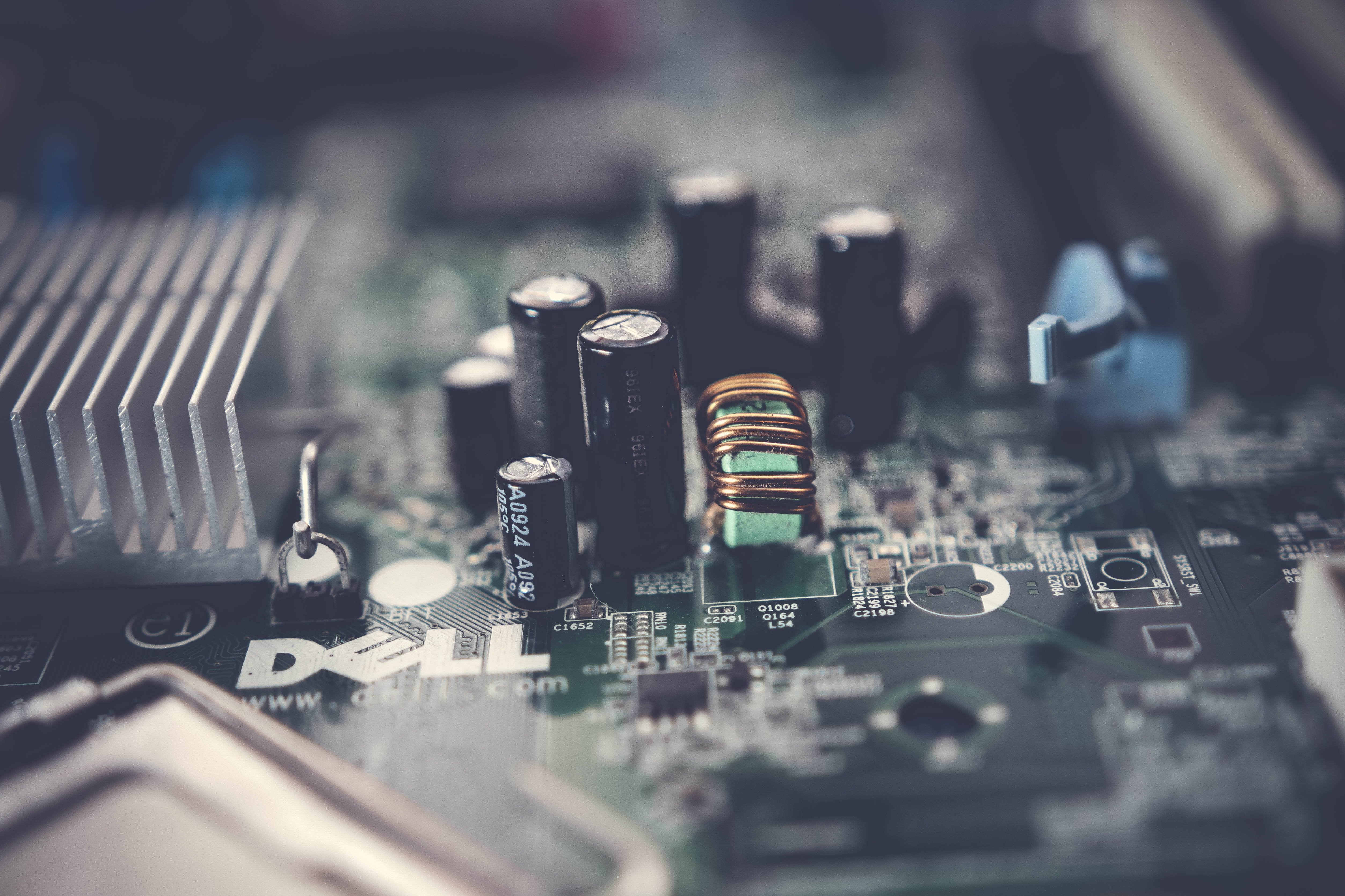 戴爾筆記型電腦 桌布 壁紙 — Dell 電腦主機板特寫，包含電容和銅線圈，淺景深效果。