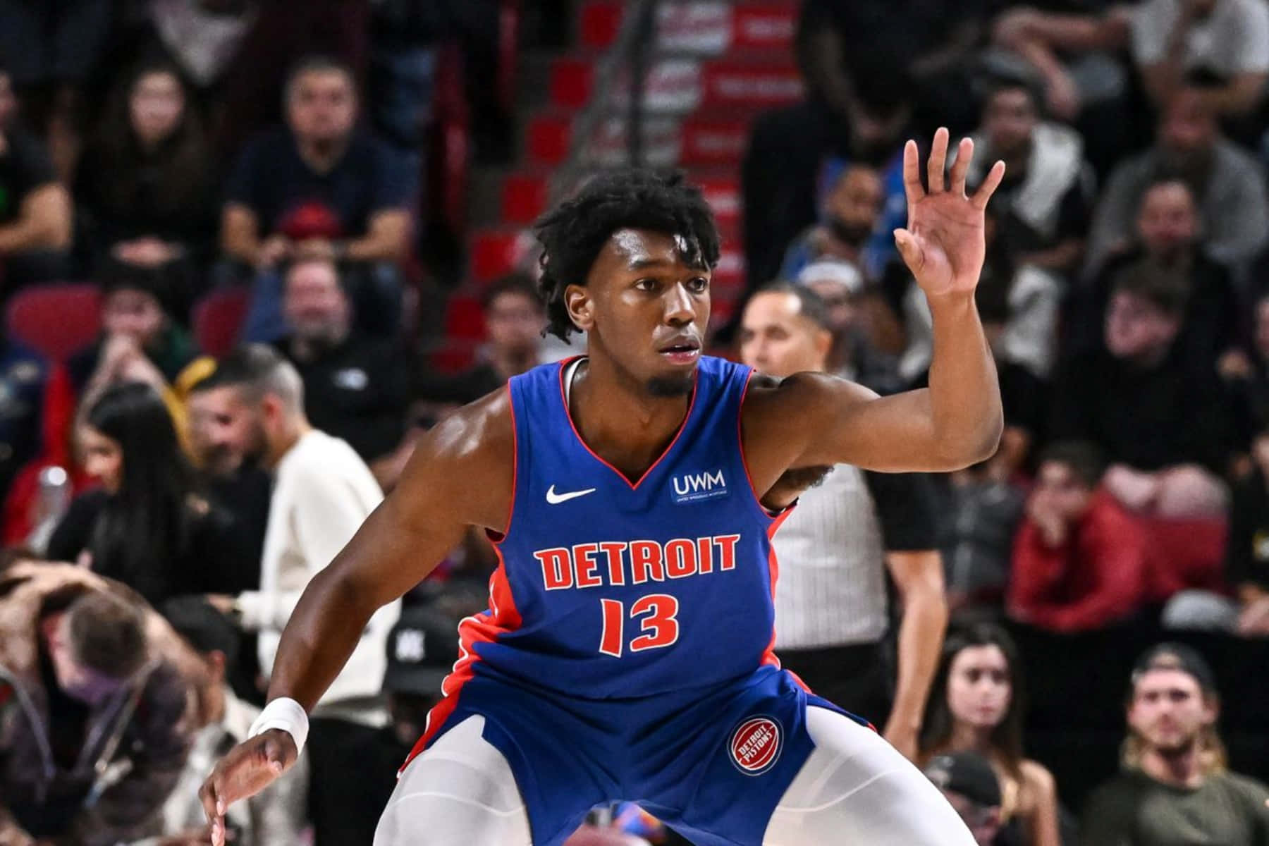 身穿底特律活塞隊服的籃球運動員在比賽中運球，背景有觀眾。 — NBA 壁紙