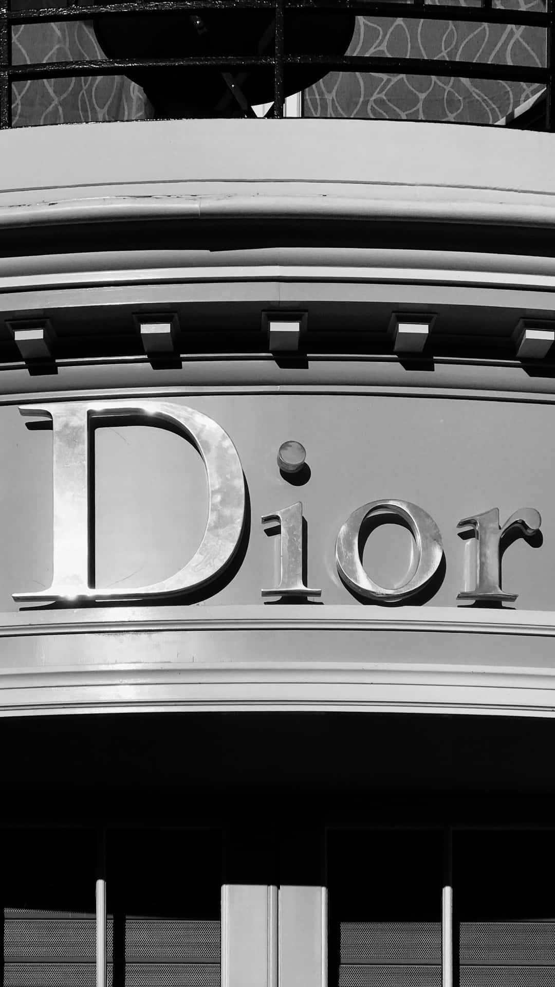  壁紙 — Dior 標誌的黑白特寫，位於時尚建築物外牆，帶有幾何建築細節。