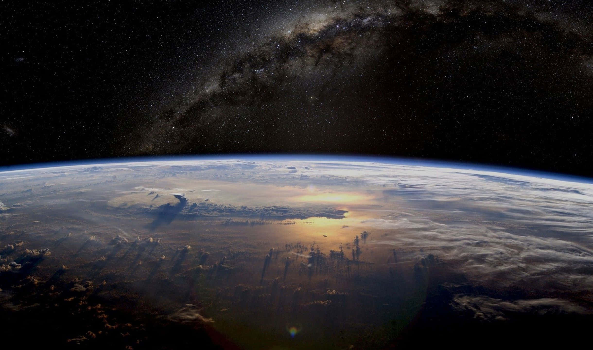 從太空看到的地球，帶有銀河和發光的雲層 — 1080P 壁紙