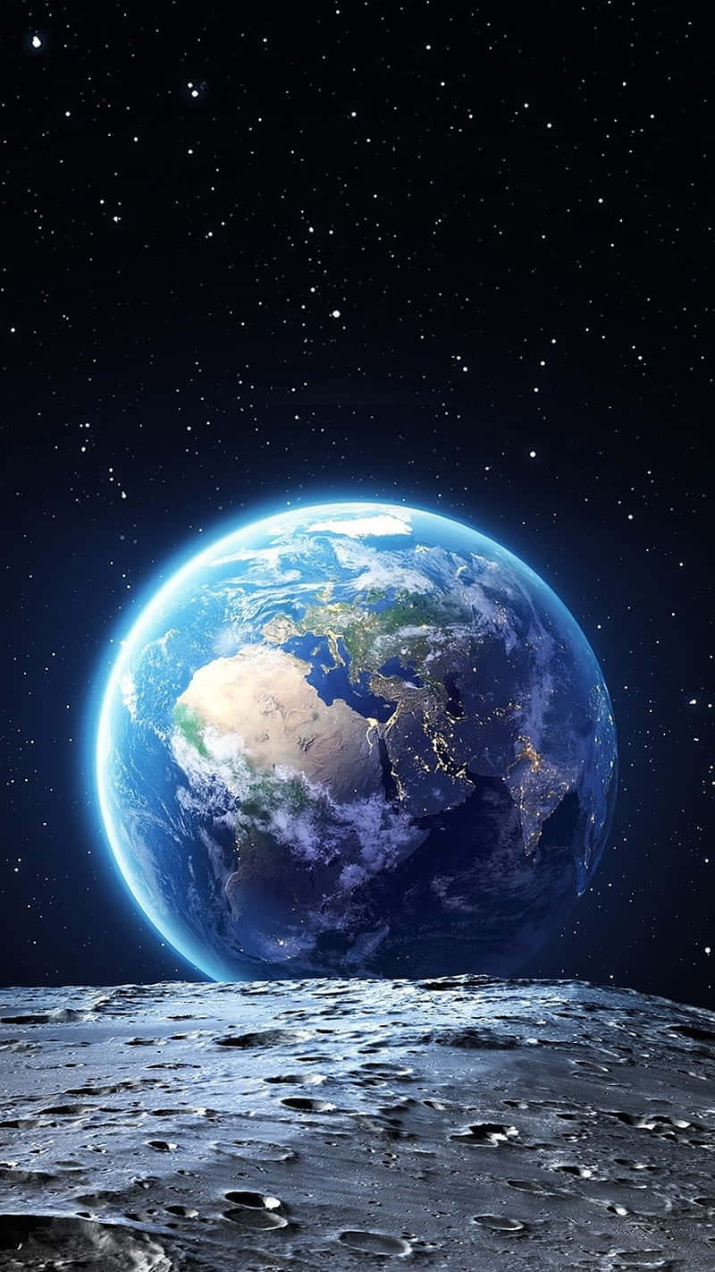  壁紙 — 地球在月球佈滿隕石坑的表面上方，於繁星點點的宇宙天空下發出藍綠光芒。