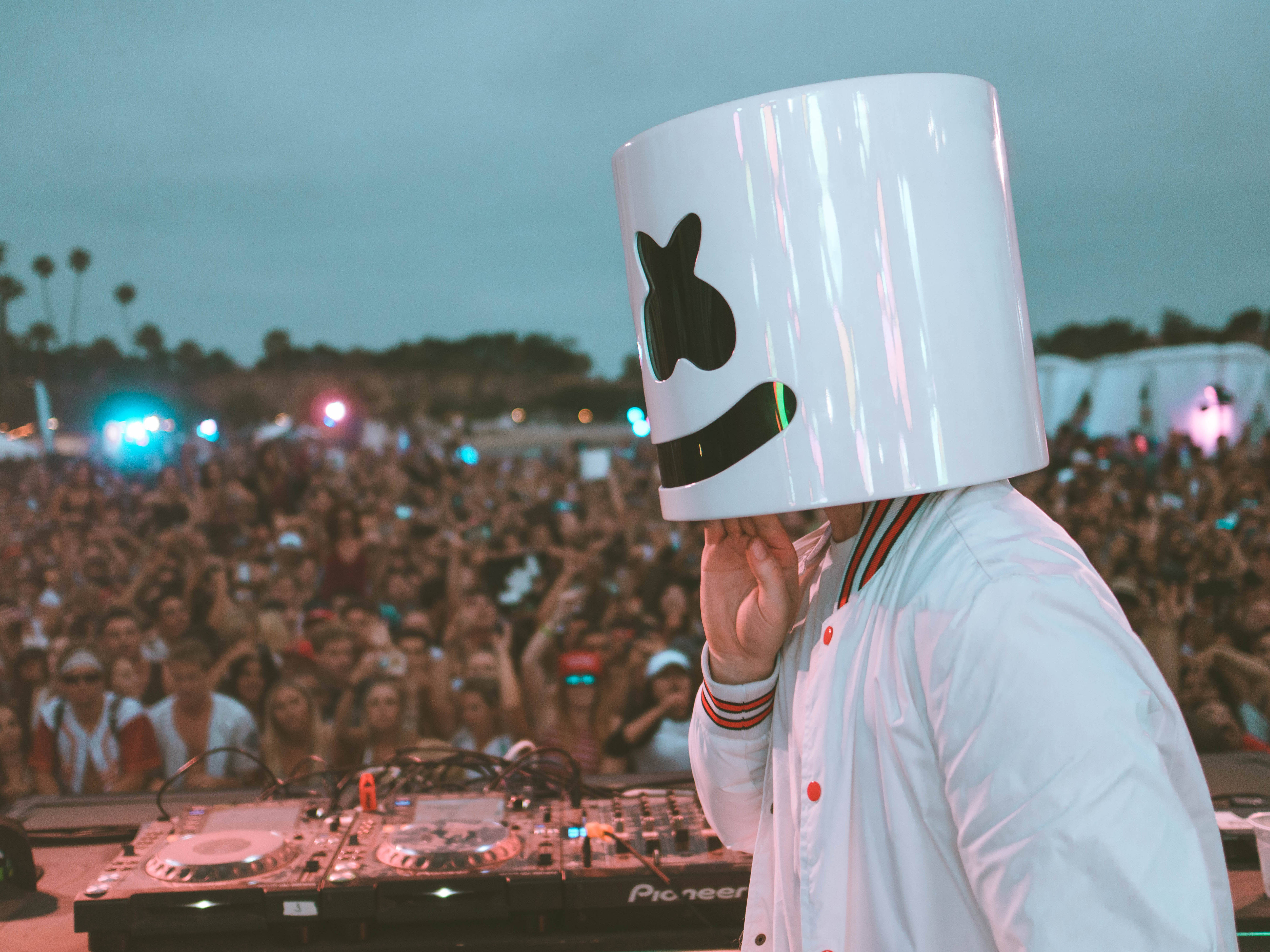Marshmello 4K 桌布 壁紙 — DJ Marshmello 戴著標誌性的白色頭盔，在黃昏時分於戶外音樂節上為大量人群表演。