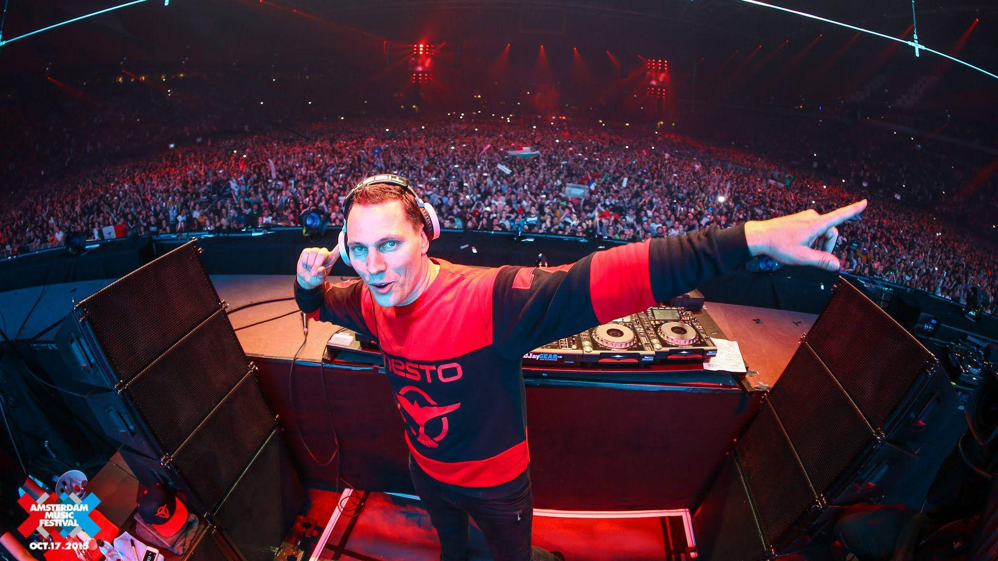 提雅斯多 桌布 壁紙 — DJ Tiësto 在阿姆斯特丹音樂節上，在充滿活力的紅色舞台燈光下，為大量觀眾注入活力。