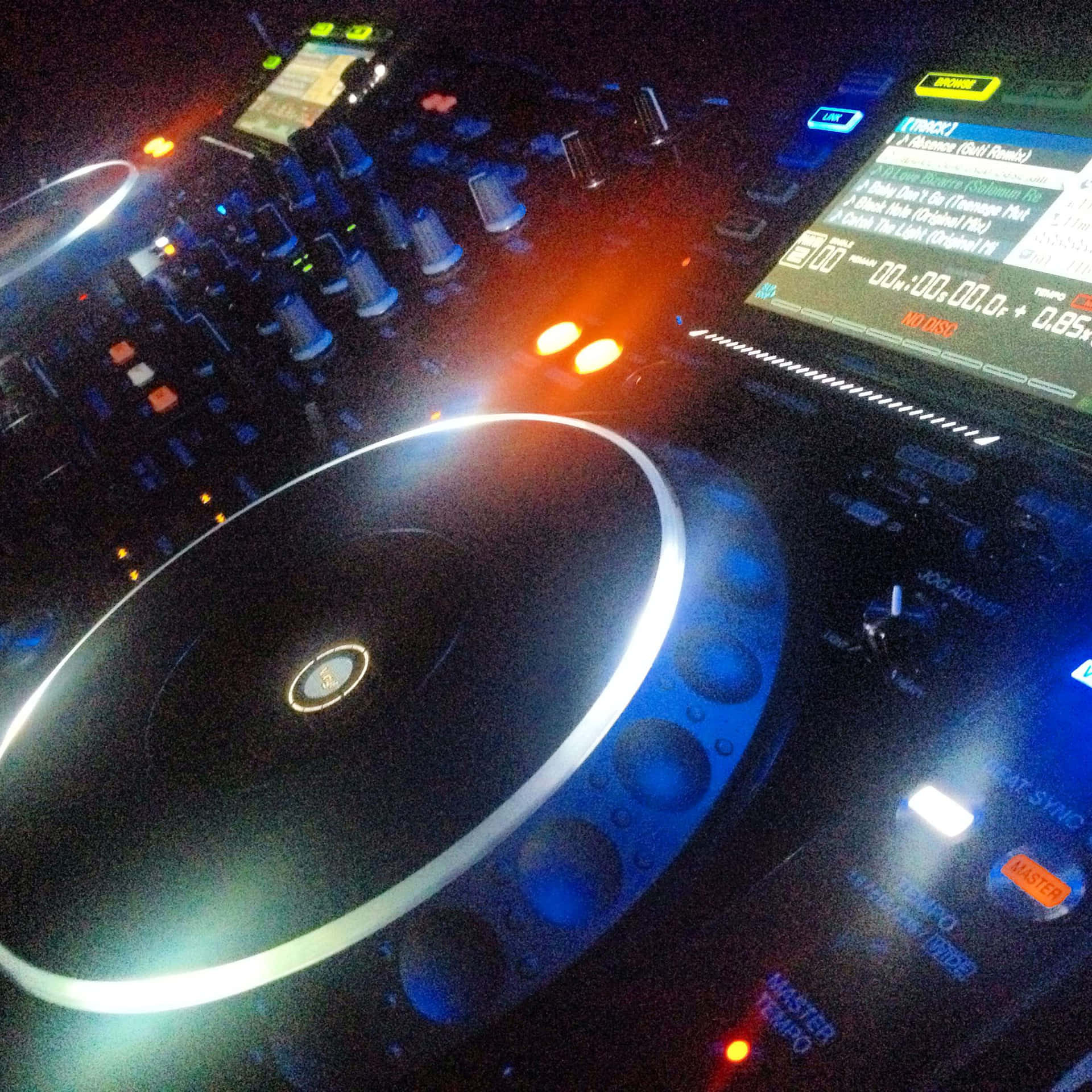 DJ 桌布 壁紙 — DJ 控制器在黑暗的俱樂部環境中發出藍色和橙色光芒的特寫。
