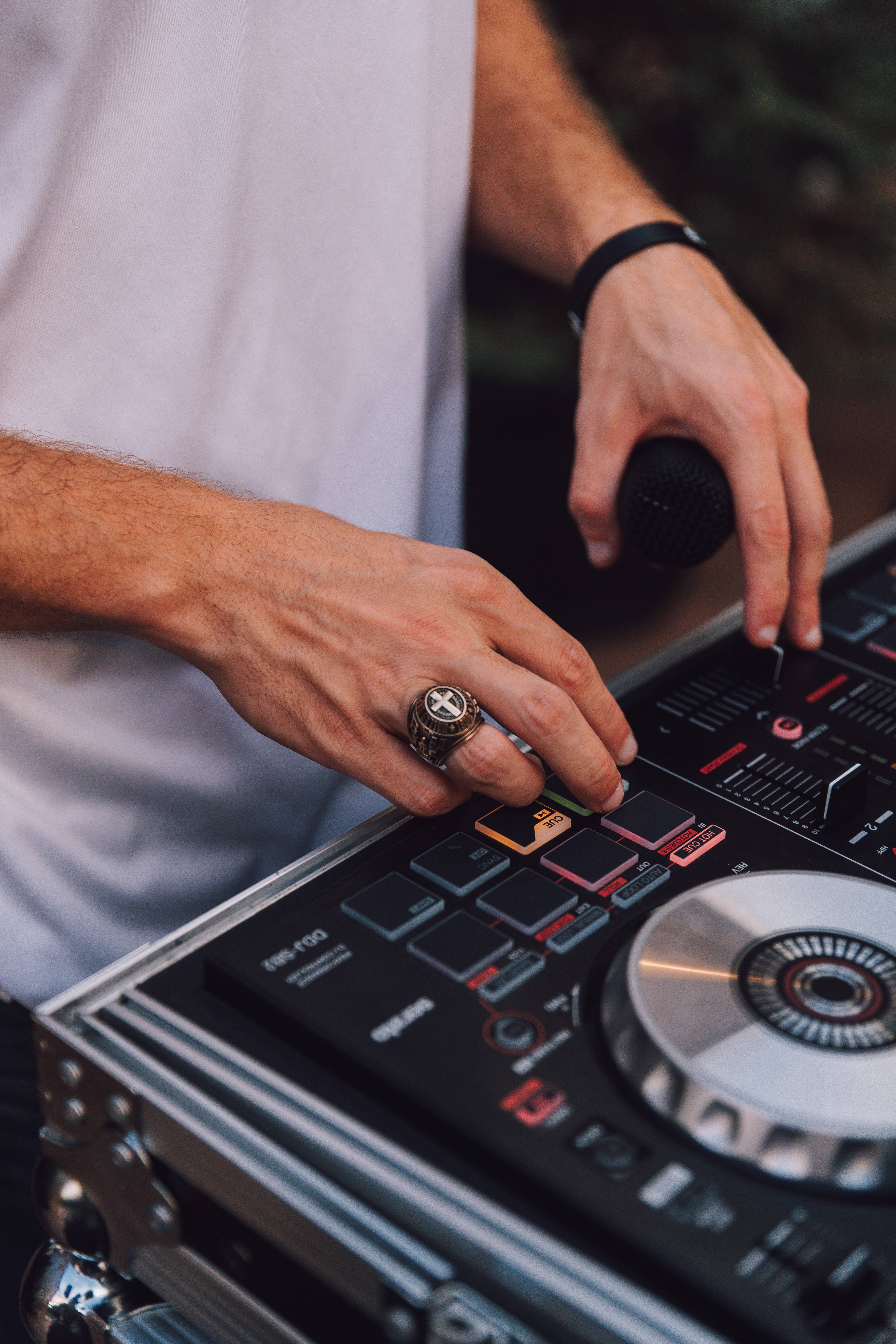 DJ 桌布 壁紙 — DJ雙手熟練操作黑色DJ控制器、銀色唱盤和彩色按鈕的特寫。