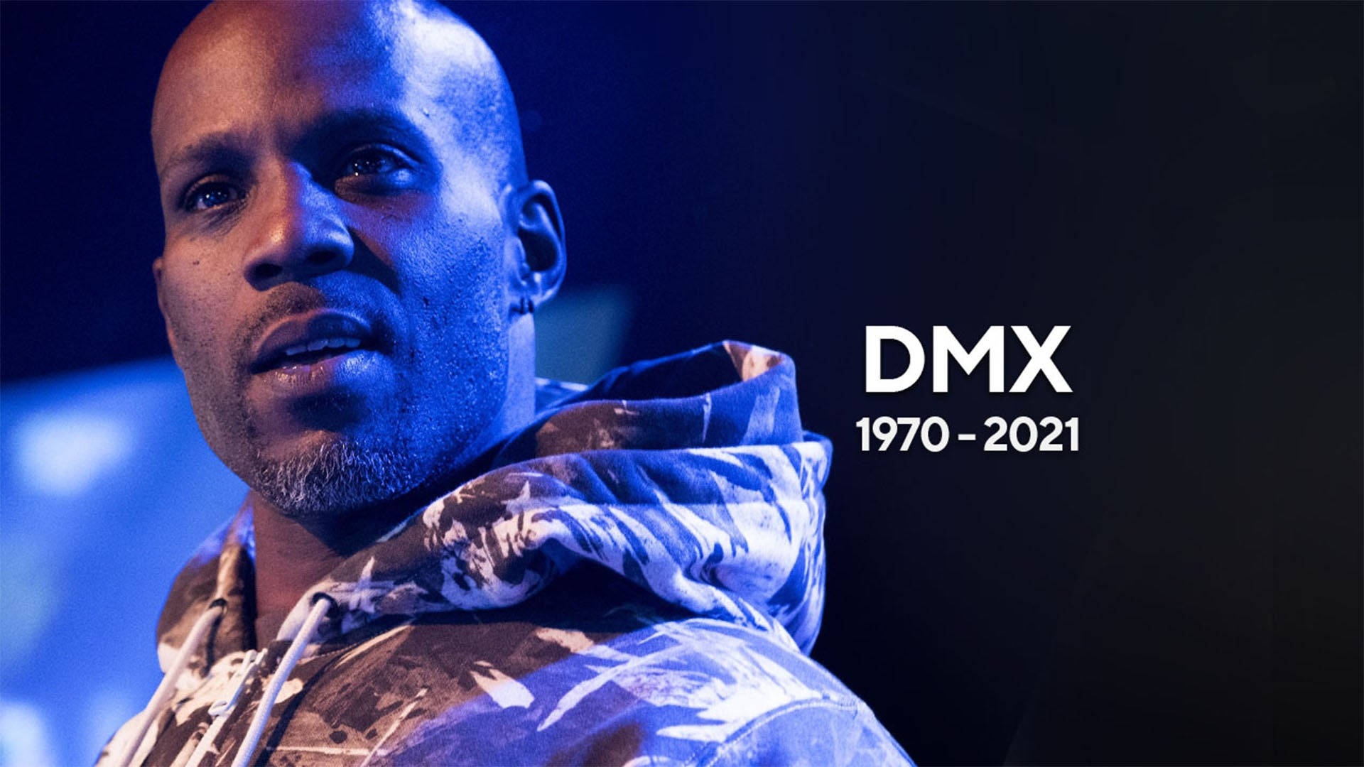 DMX 桌布 壁紙 — DMX 身穿圖案連帽上衣，在藍色舞台燈光下的特寫肖像，附有紀念他生平 1970-2021 的文字。