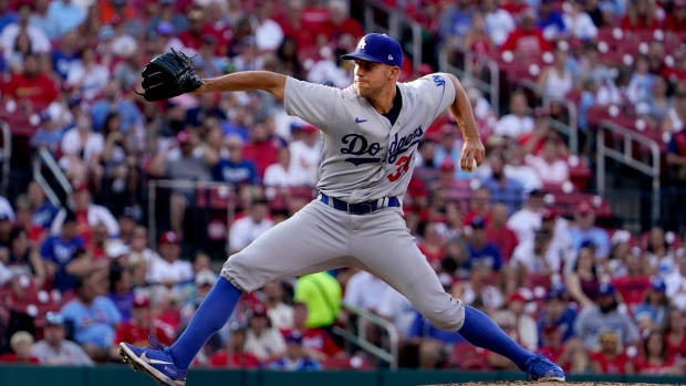 棒球投手在日間比賽中投球，背景有球迷。 — MLB 壁紙