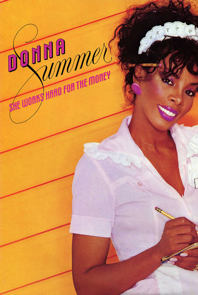 復古 桌布 壁紙 — Donna Summer 身穿白色蕾絲邊襯衫，在鮮黃色木牆前手持鉛筆，露出燦爛笑容。