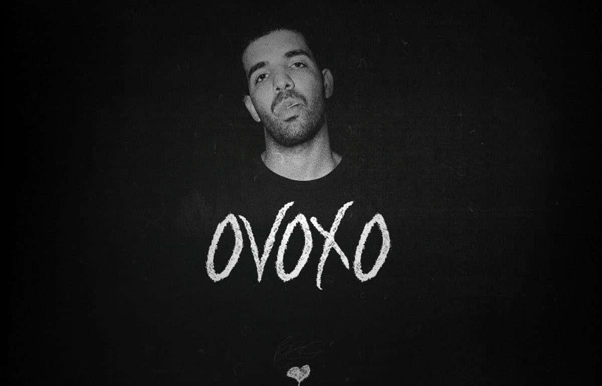 Drake 桌布 壁紙 — Drake 向上看的黑白肖像，穿著一件用粉筆白色字寫著「OVOXO」的襯衫。