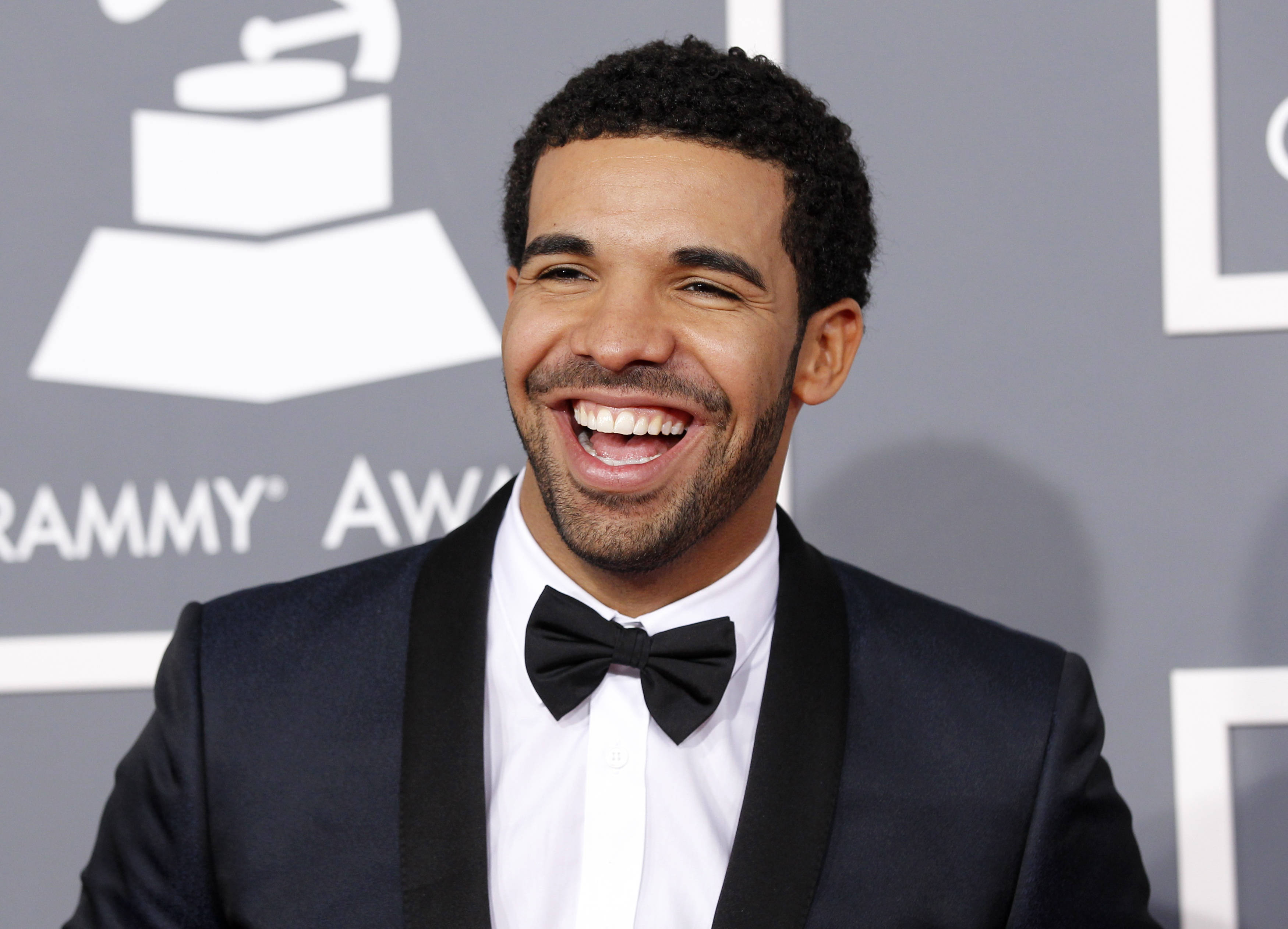 Drake 桌布 壁紙 — Drake 在葛萊美獎背景下穿著黑色燕尾服，喜氣洋洋。