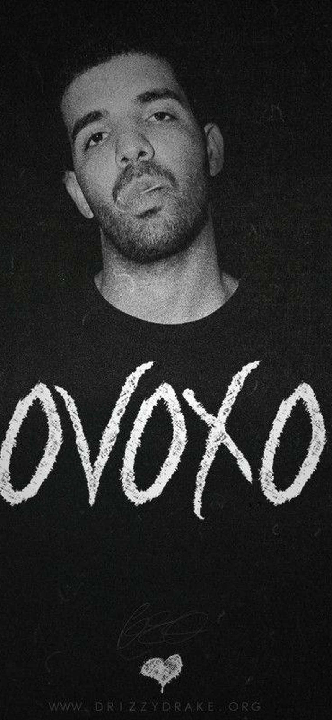 Aesthetic Drake 桌布 壁紙 — Drake 穿著印有粗體塗鴉風格字體 'OVOXO' 襯衫的黑白肖像。