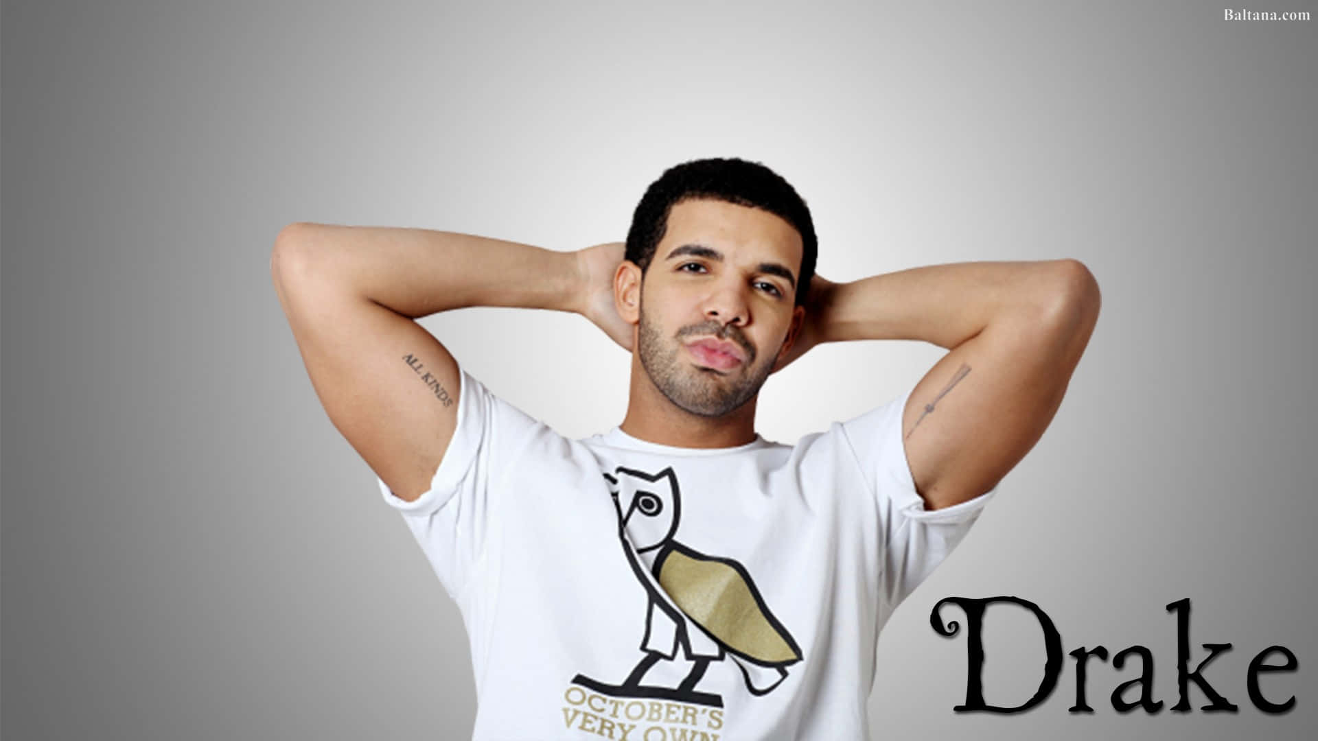 桌布 壁紙 — Drake 自信地擺姿勢，雙手放在腦後，身穿帶有貓頭鷹圖案的白色T恤，背景是純灰色攝影棚。