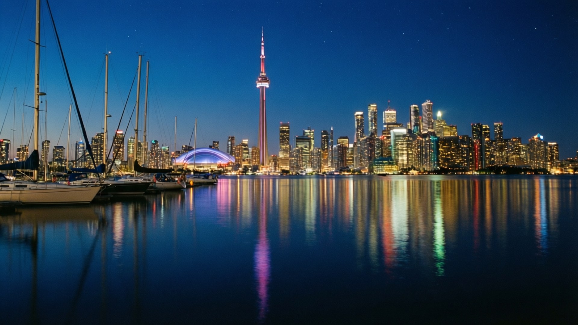 Toronto Harbour Night 壁紙 — 多倫多夜景，CN塔亮起，帆船停泊在平靜的水面上，倒映著城市燈光。