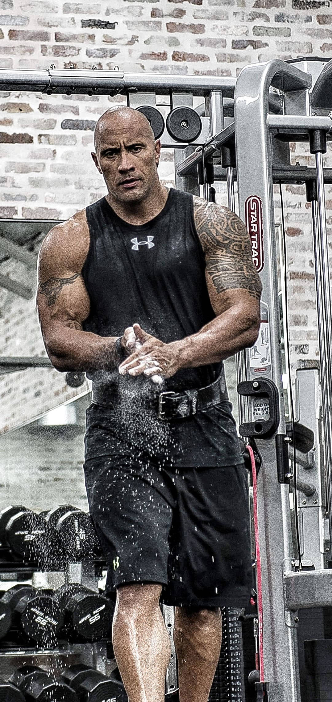 The Rock 桌布 壁紙 — Dwayne Johnson 在健身房中對著磚牆背景拍打手上的粉筆灰。