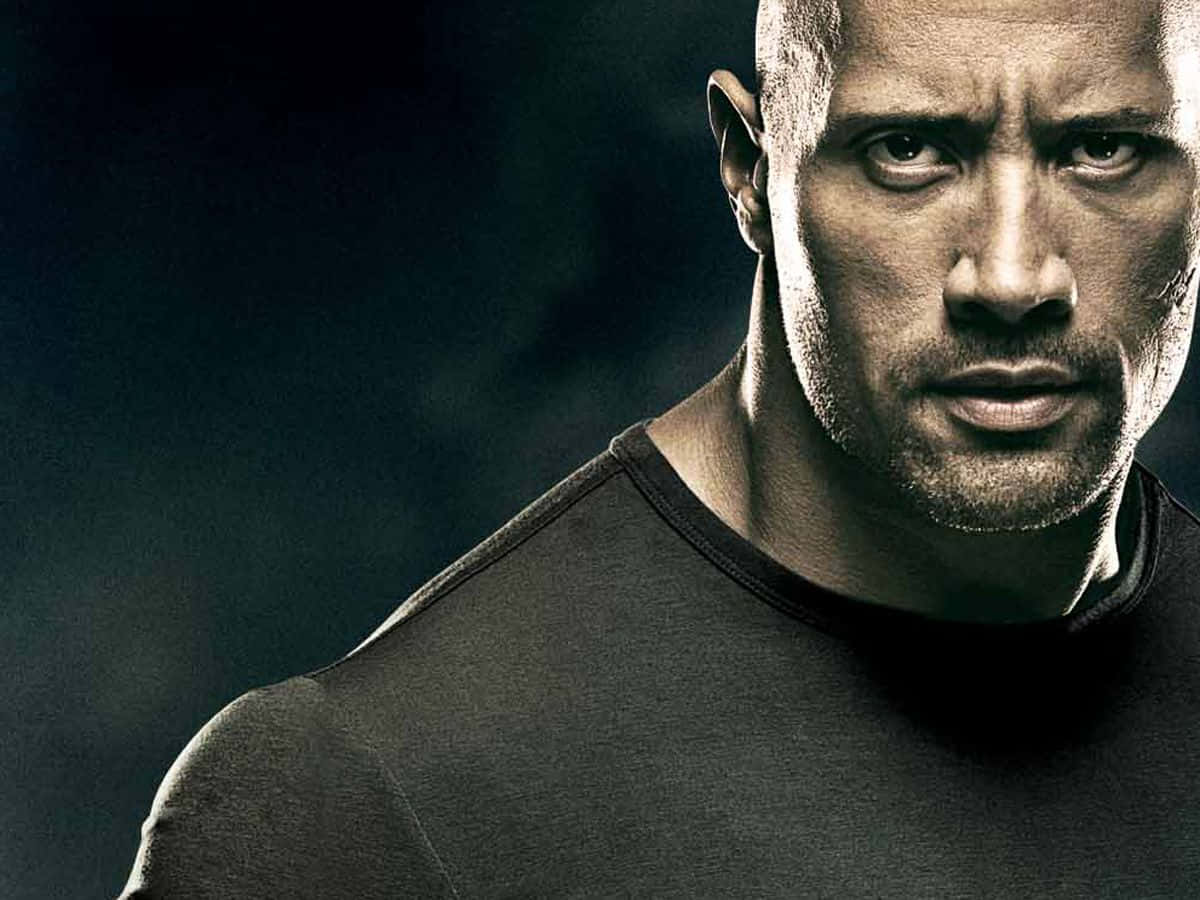The Rock 桌布 壁紙 — Dwayne Johnson 的特寫肖像，眼神凌厲，肌肉線條分明，背景是黑暗陰沉的氛圍。