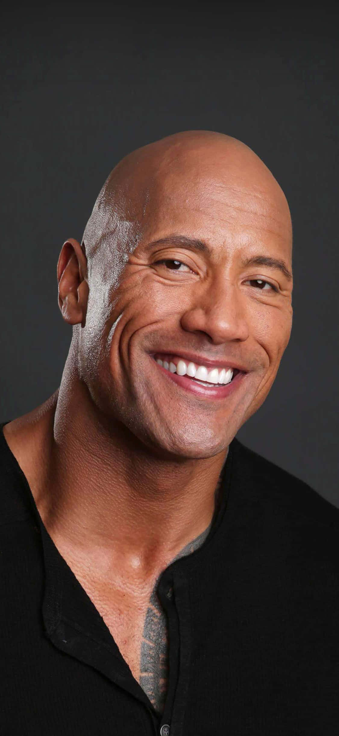 Celebrity 桌布 壁紙 — Dwayne Johnson 的特寫肖像，在深灰色的工作室背景前燦爛微笑。