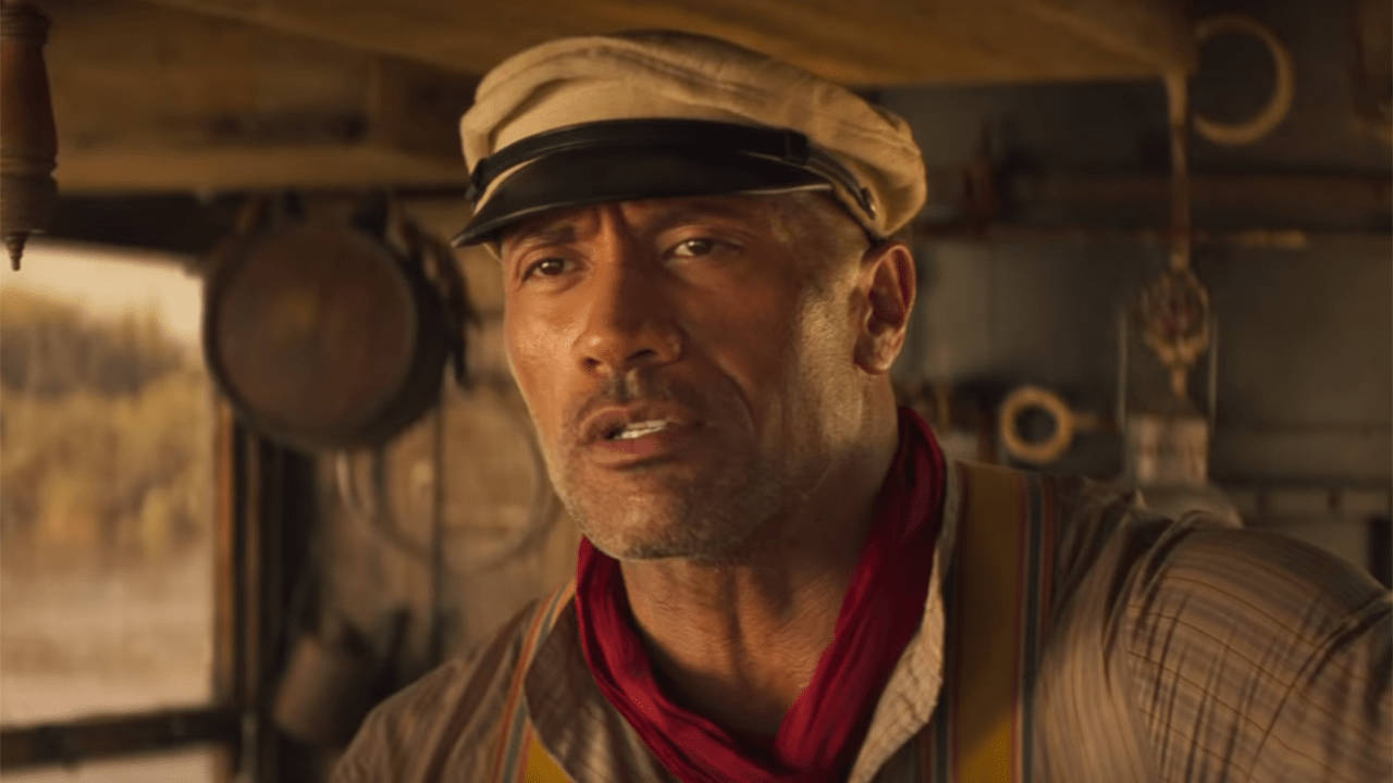 叢林奇航 桌布 壁紙 — Dwayne Johnson 飾演一位粗獷的火車司機，身處溫暖燈光下的復古火車駕駛室，內有木質面板和懸掛工具。