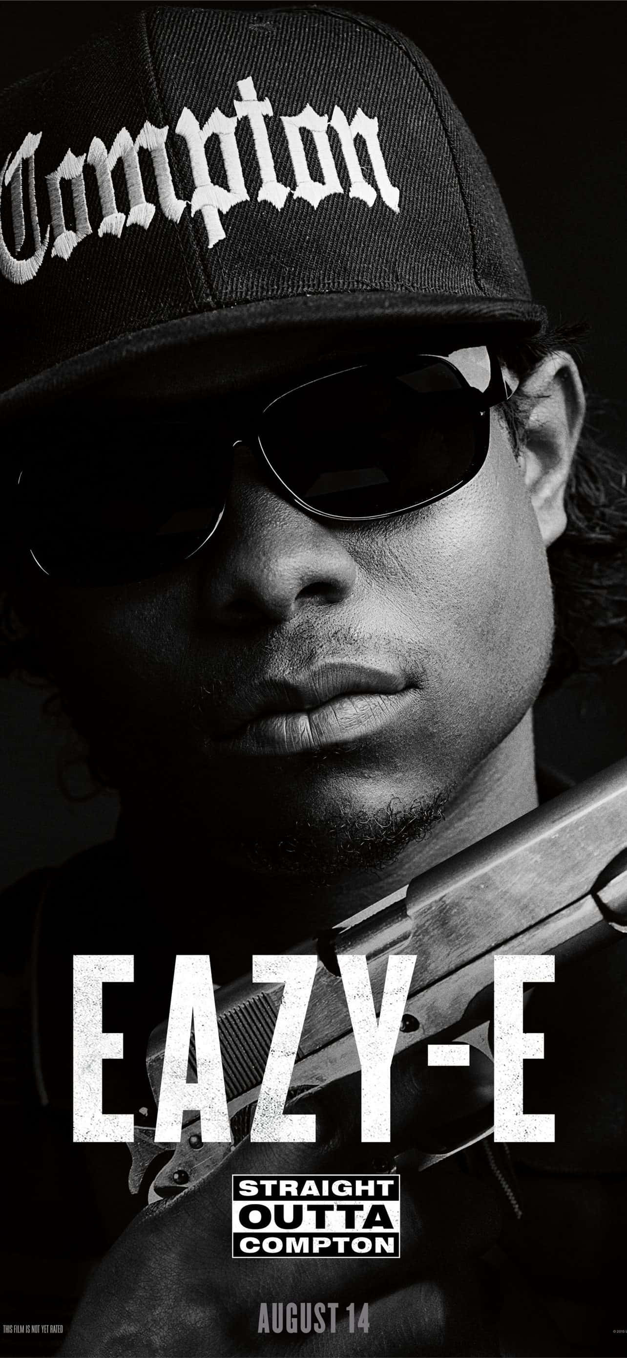Hip Hop Rappers 桌布 壁紙 — Eazy-E 戴著 Compton 帽和太陽眼鏡，手持槍枝的黑白肖像，帶有粗體文字疊加。