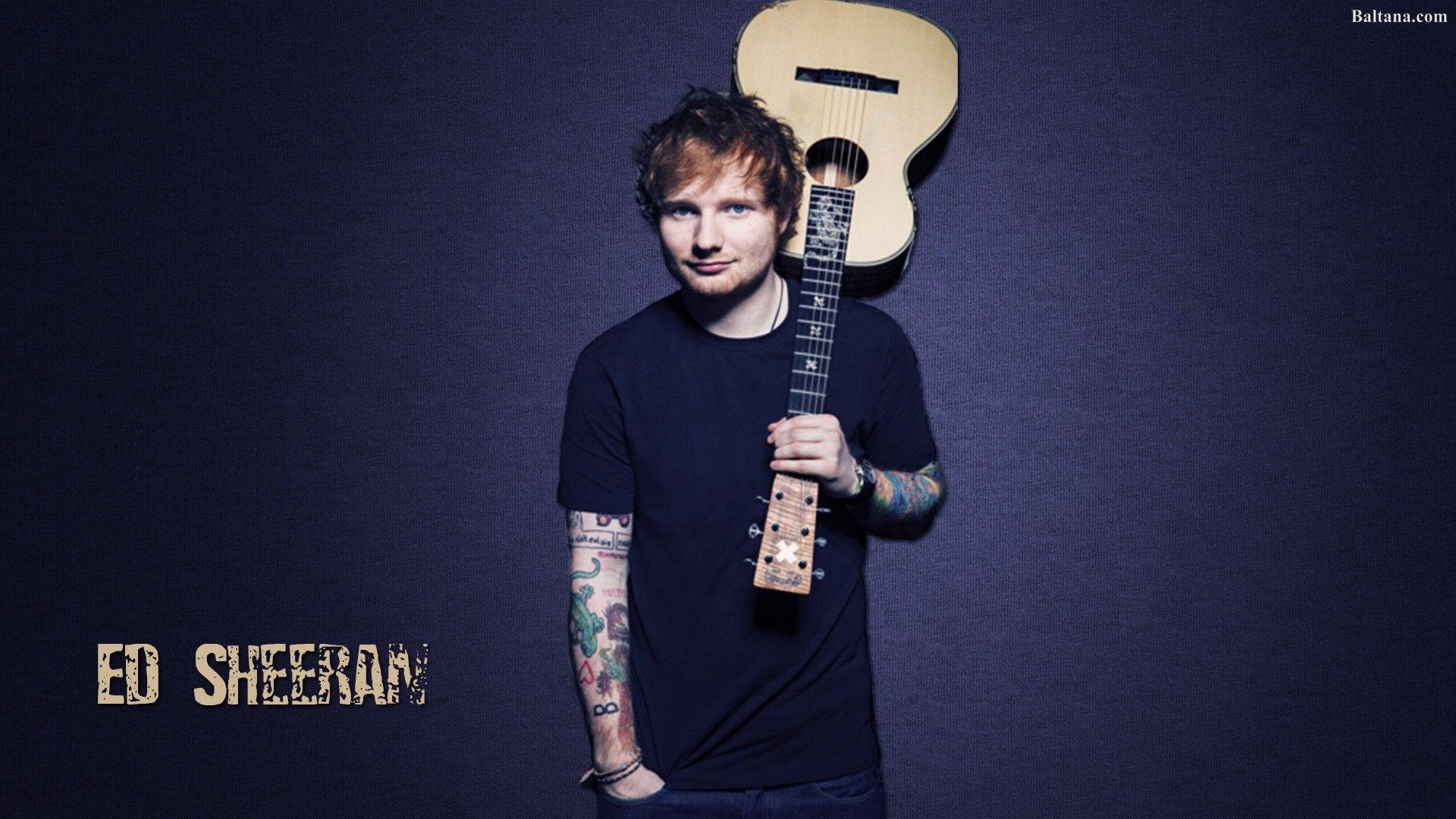 紅景天 桌布 壁紙 — Ed Sheeran 自信地站立，手持一把原聲吉他，背景為深色紋理，他的名字以風格化文字顯示。