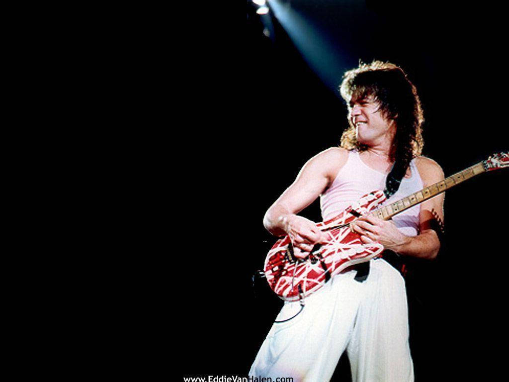 Eddie 桌布 壁紙 — Eddie Van Halen 在黑暗舞台的聚光燈下彈奏紅白條紋吉他。