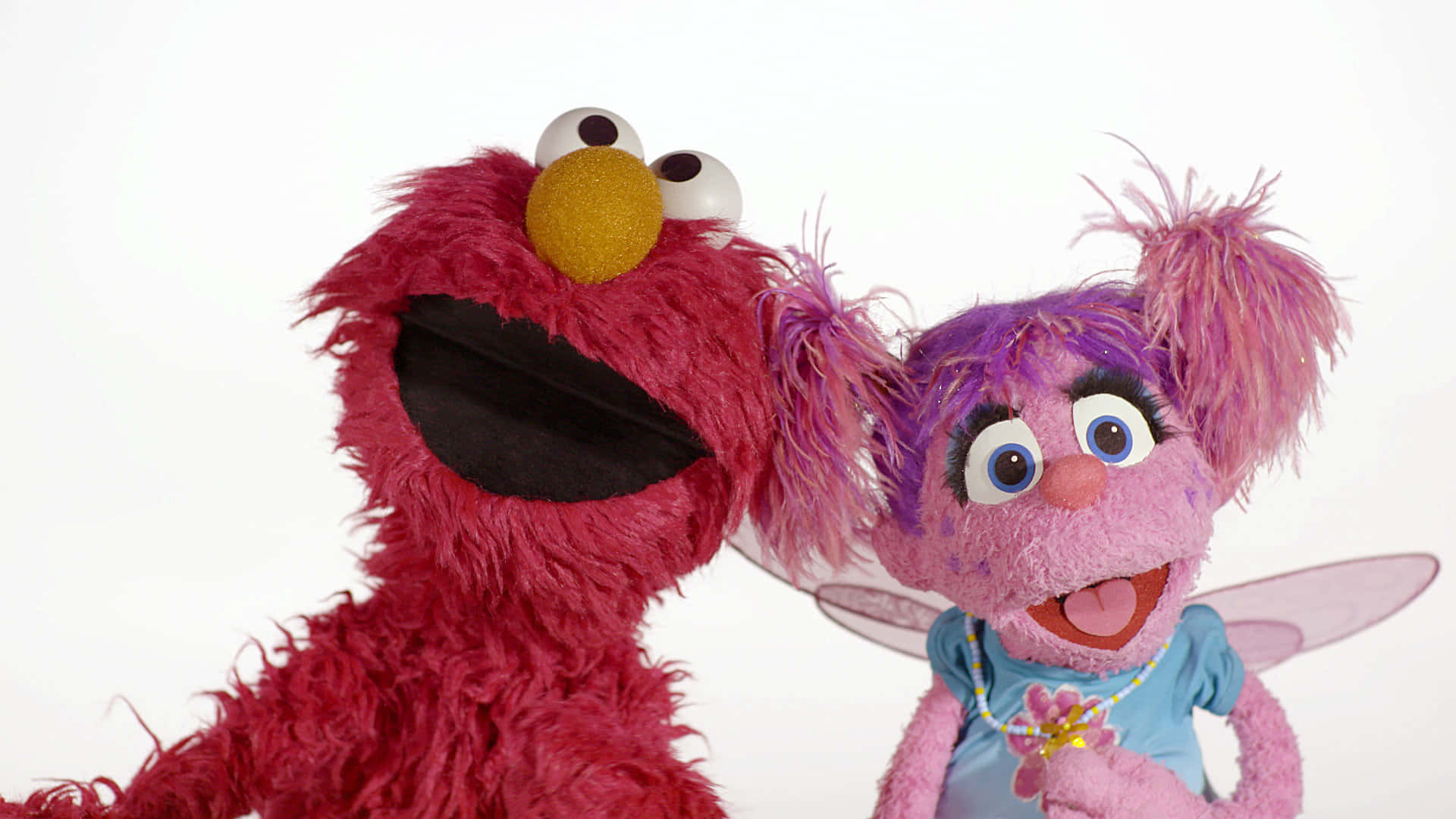 Elmo 桌布 壁紙 — Elmo 和 Abby Cadabby 在純白色背景前開心微笑，呈現歡樂的攝影棚拍攝效果。