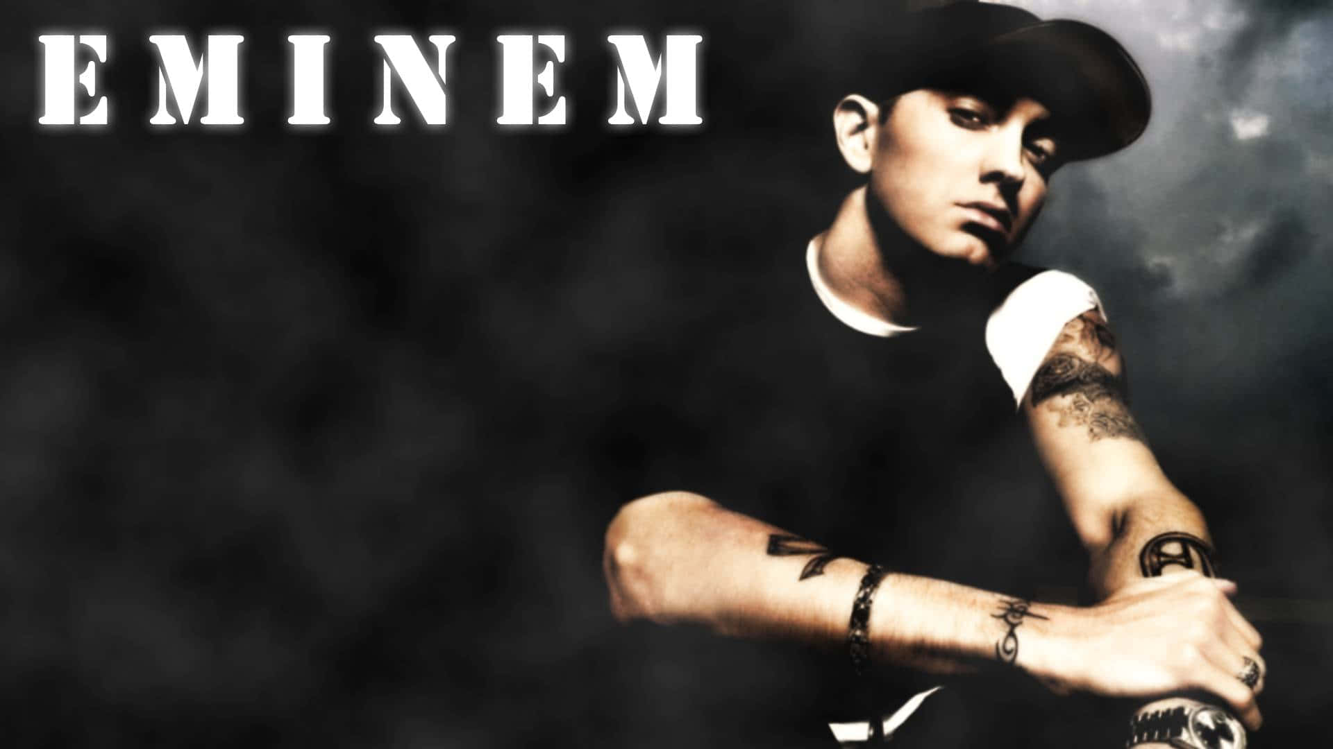 阿姆 桌布 壁紙 — Eminem 在昏暗煙霧背景及戲劇性燈光下，交叉雙臂，眼神凌厲。