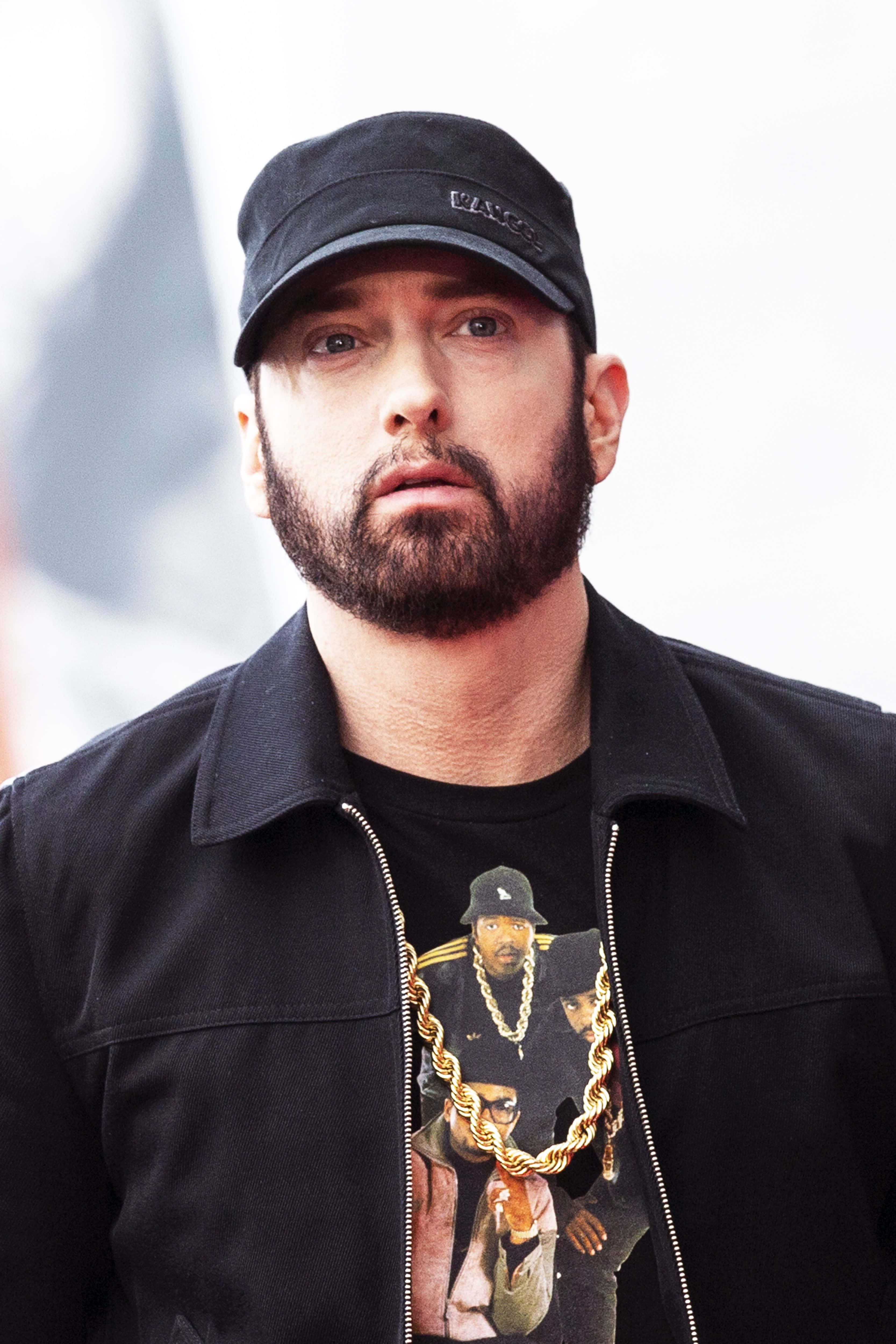 阿姆 桌布 壁紙 — Eminem 的特寫肖像，戴著黑色帽子與外套，穿著有金色鏈條設計的圖案T恤。
