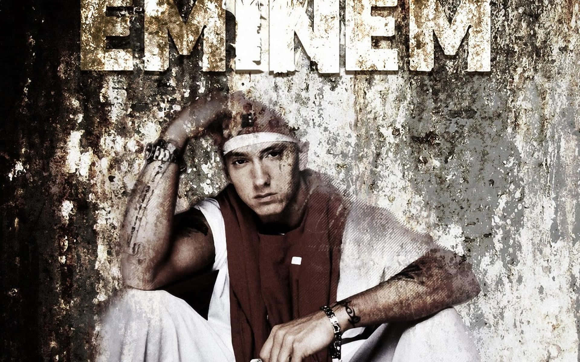 阿姆 桌布 壁紙 — Eminem 靠著一面風化的牆壁坐著，他的名字以粗體顯示在上方，手臂上的刺青清晰可見。