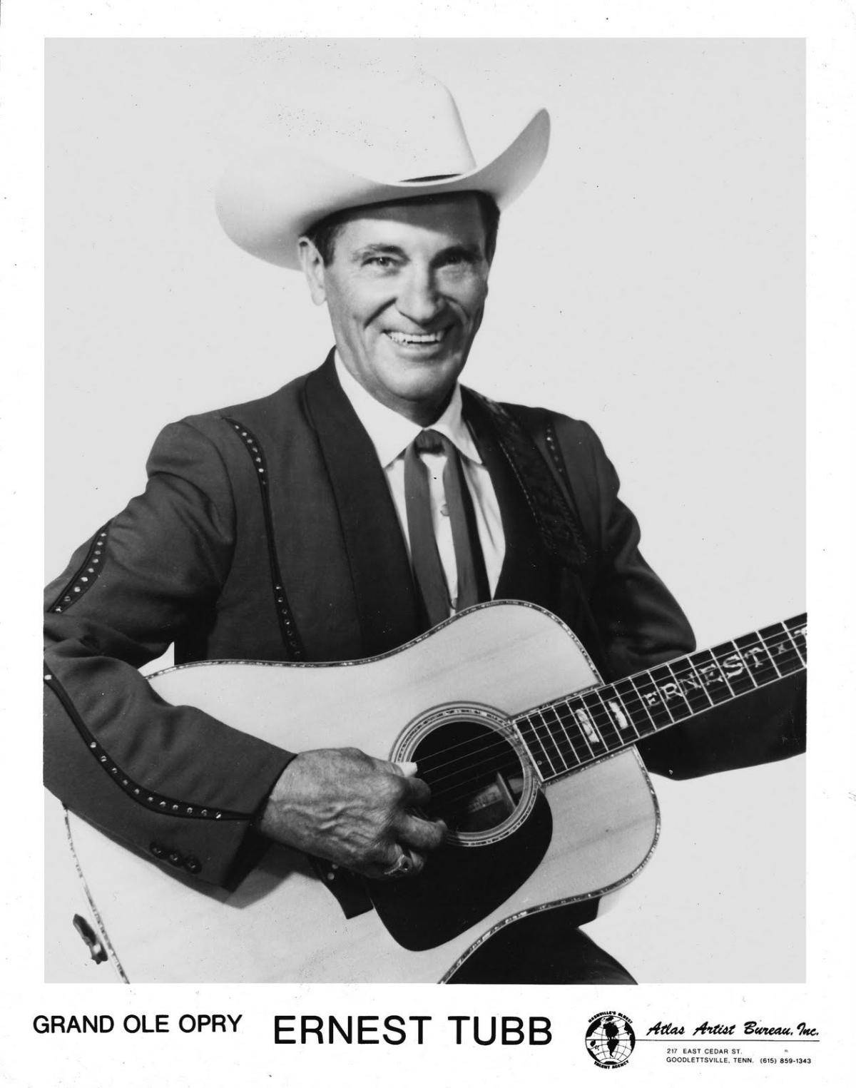 Singer 桌布 壁紙 — Ernest Tubb 在經典黑白工作室肖像中溫暖微笑，手持一把原聲吉他。
