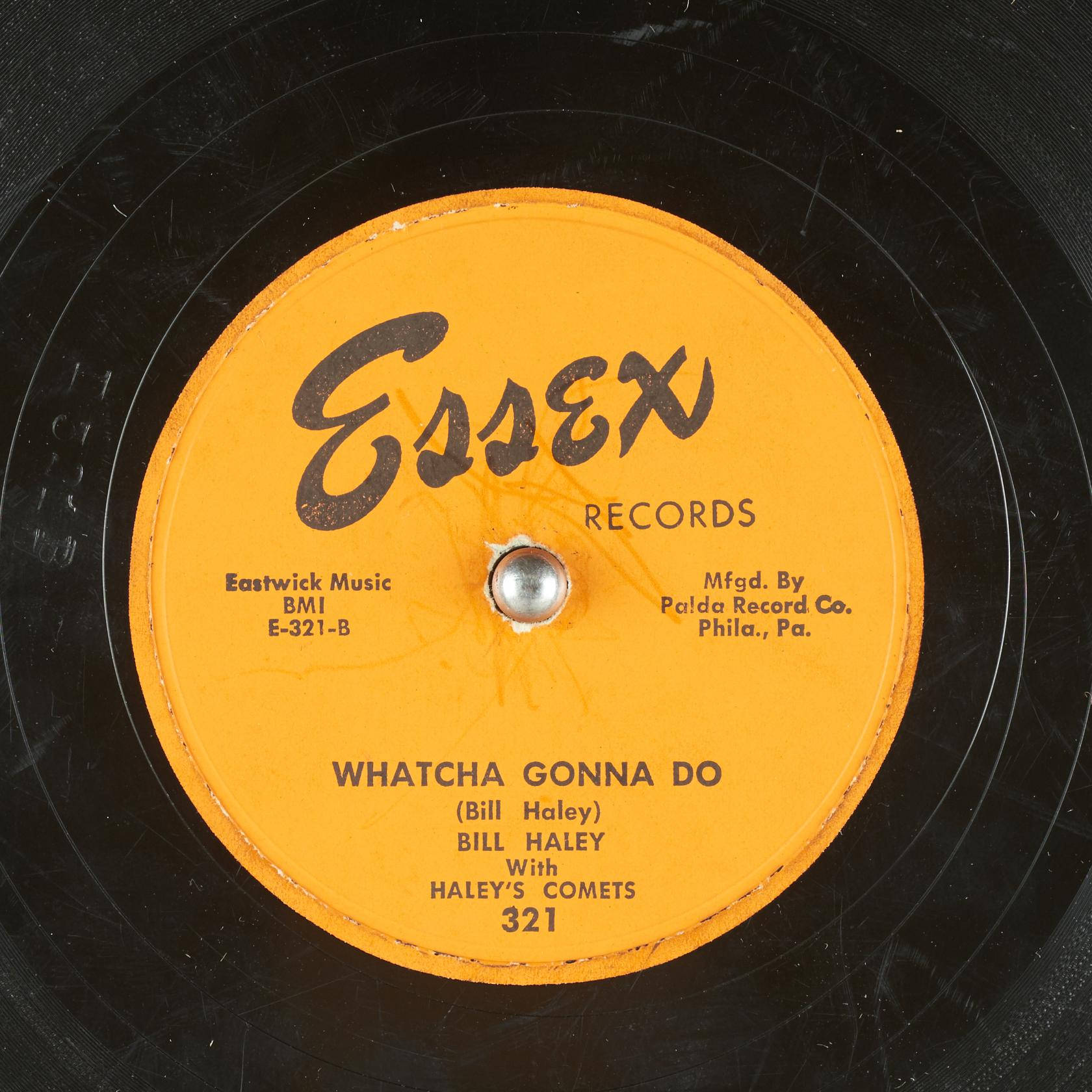 vinyl 桌布 壁紙 — Essex Records 復古黑膠唱片標籤的特寫，帶有醒目的橙色中心和黑色文字，顯示 Bill Haley 的歌曲 Whatcha Gonna Do。