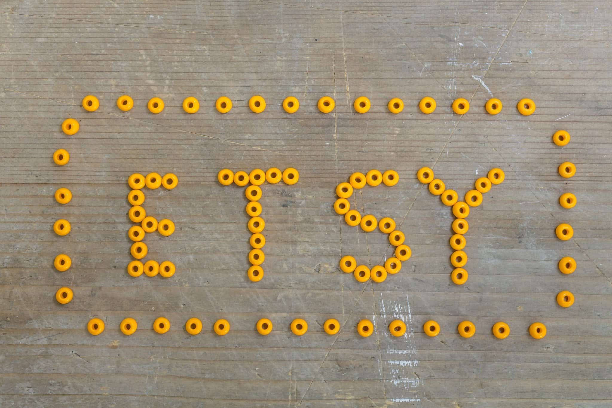 etsy 桌布 壁紙 — 「ETSY」這個字用鮮黃色珠子在風化的木質表面上拼出來。