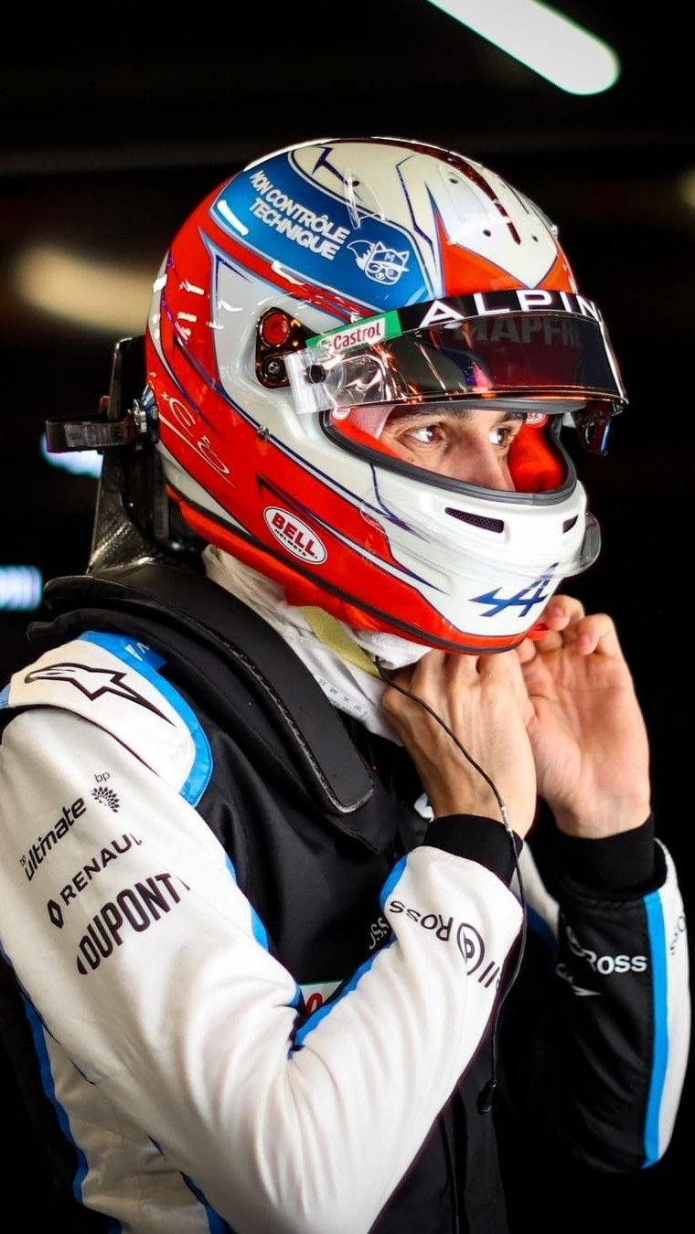 F1車手在明亮燈光下穿著賽車服調整頭盔裝備。 — F1手機壁紙 壁紙