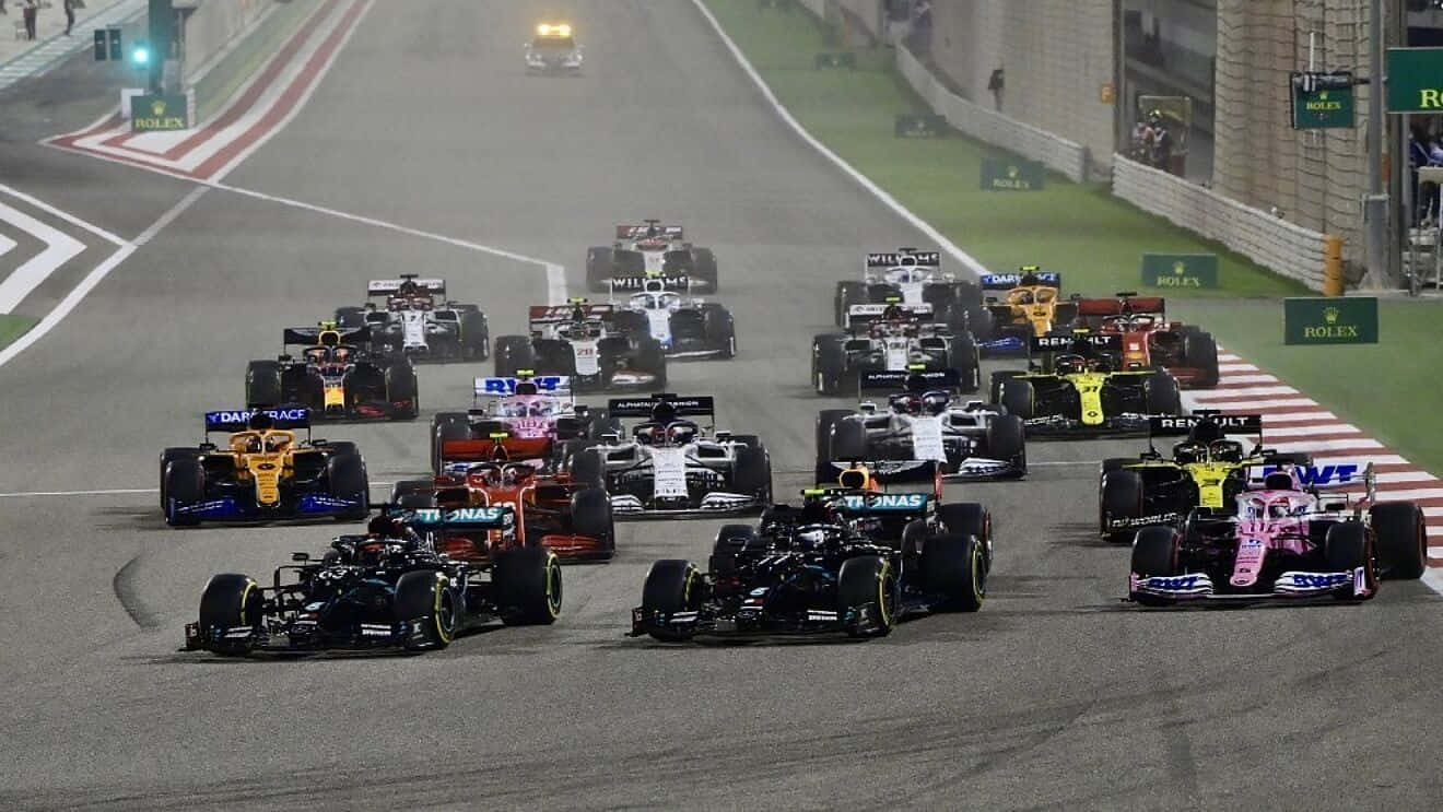 F1 桌布 壁紙 — F1 賽車在夜間濕滑的賽道上咆哮，明亮的車頭燈劃破迷霧。