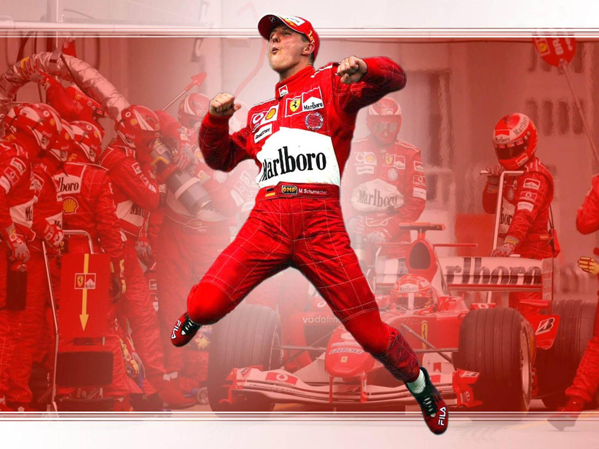michael 桌布 壁紙 — F1車手麥可·舒馬克以紅色法拉利賽車服跳躍慶祝勝利，團隊在他身後。