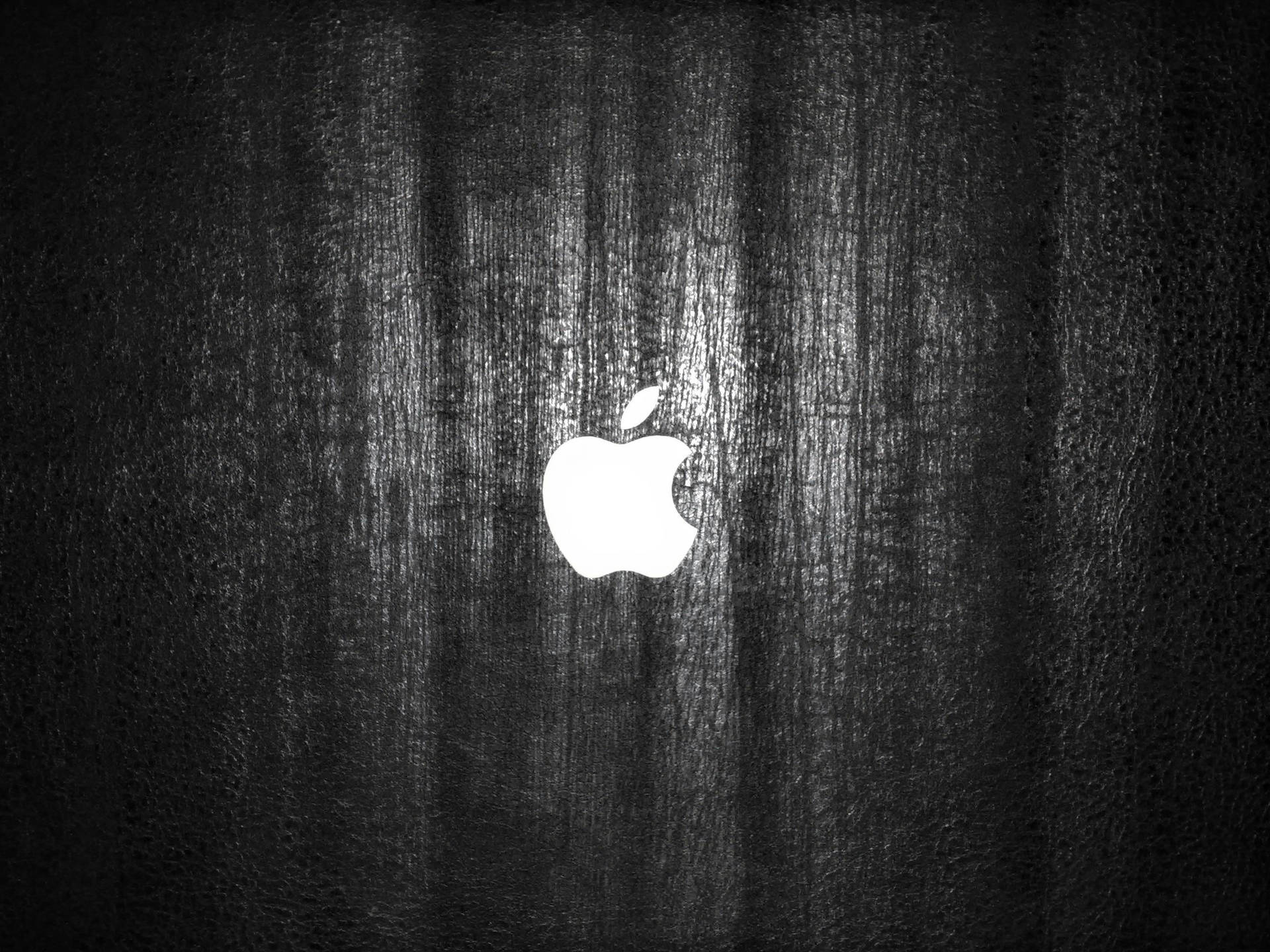 深色木紋背景上的白色Apple標誌 — 4K 壁紙