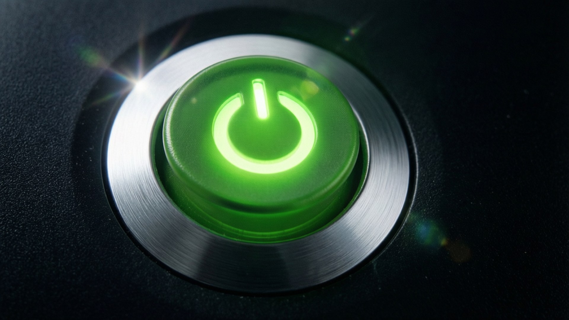 Xbox 360 Power Button Macro 壁紙 — 一個發光的綠色電源按鈕，帶有金屬銀色環，置於帶有鏡頭光暈的深色紋理表面上。