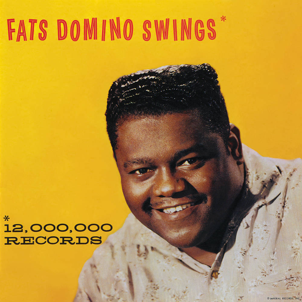 Legend 桌布 壁紙 — Fats Domino 在鮮黃色背景上溫暖微笑，這是他的《Swings》專輯封面。