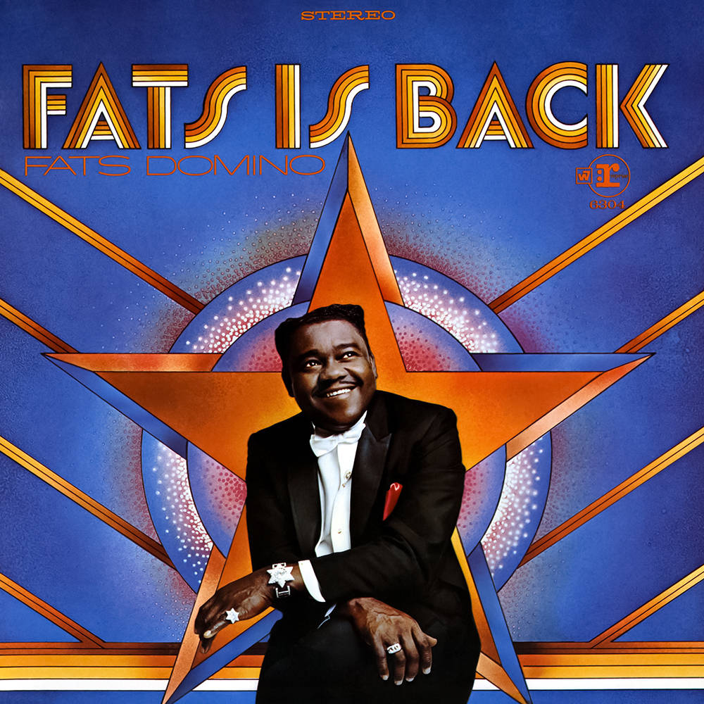 Legend 桌布 壁紙 — Fats Domino 身穿燕尾服，在充滿活力的藍色和橙色星爆圖案專輯封面背景下自信微笑。