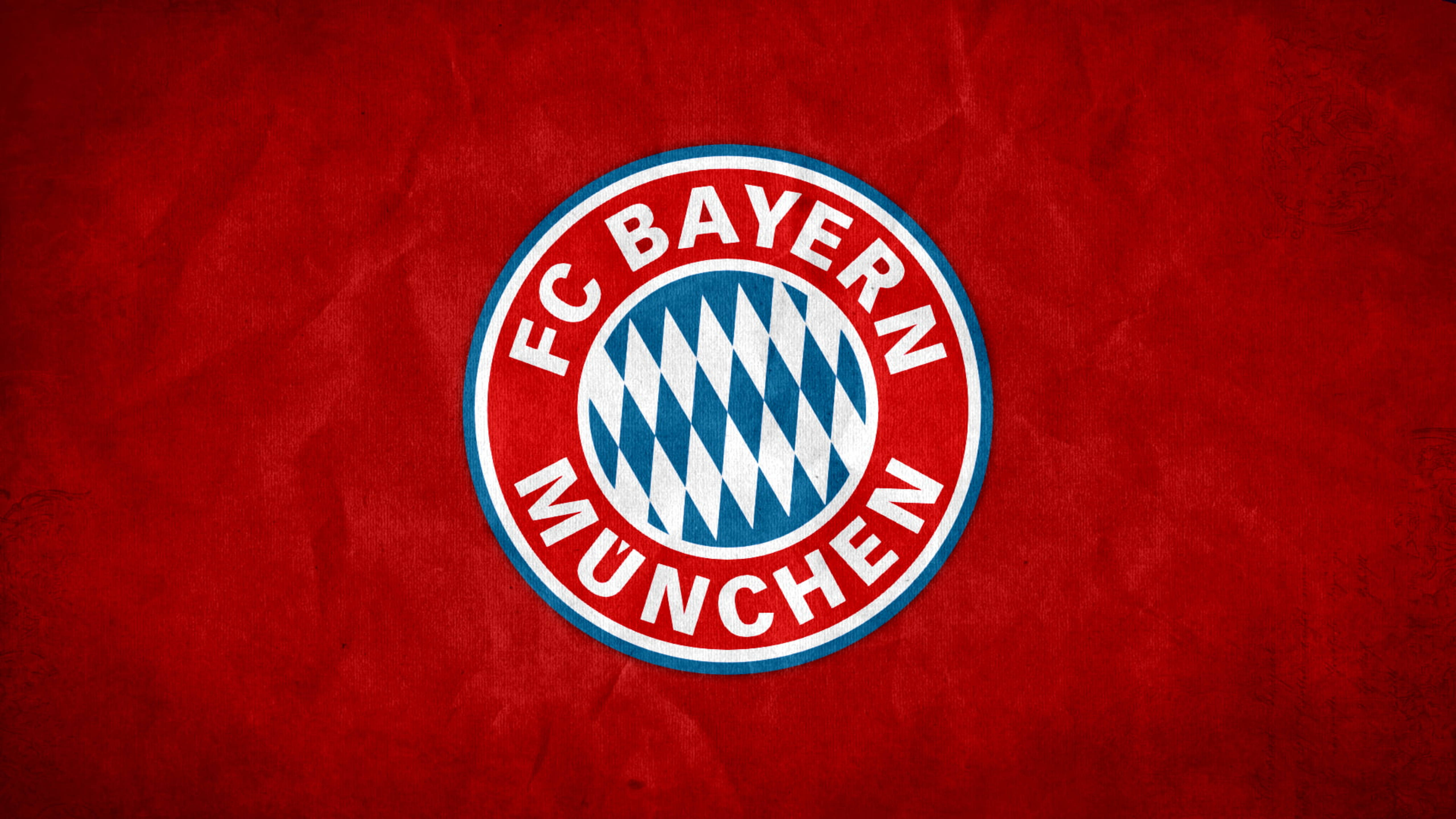Bayern 桌布 壁紙 — FC Bayern München 標誌居中於紋理紅色布料背景上，帶有醒目的白色和藍色細節。