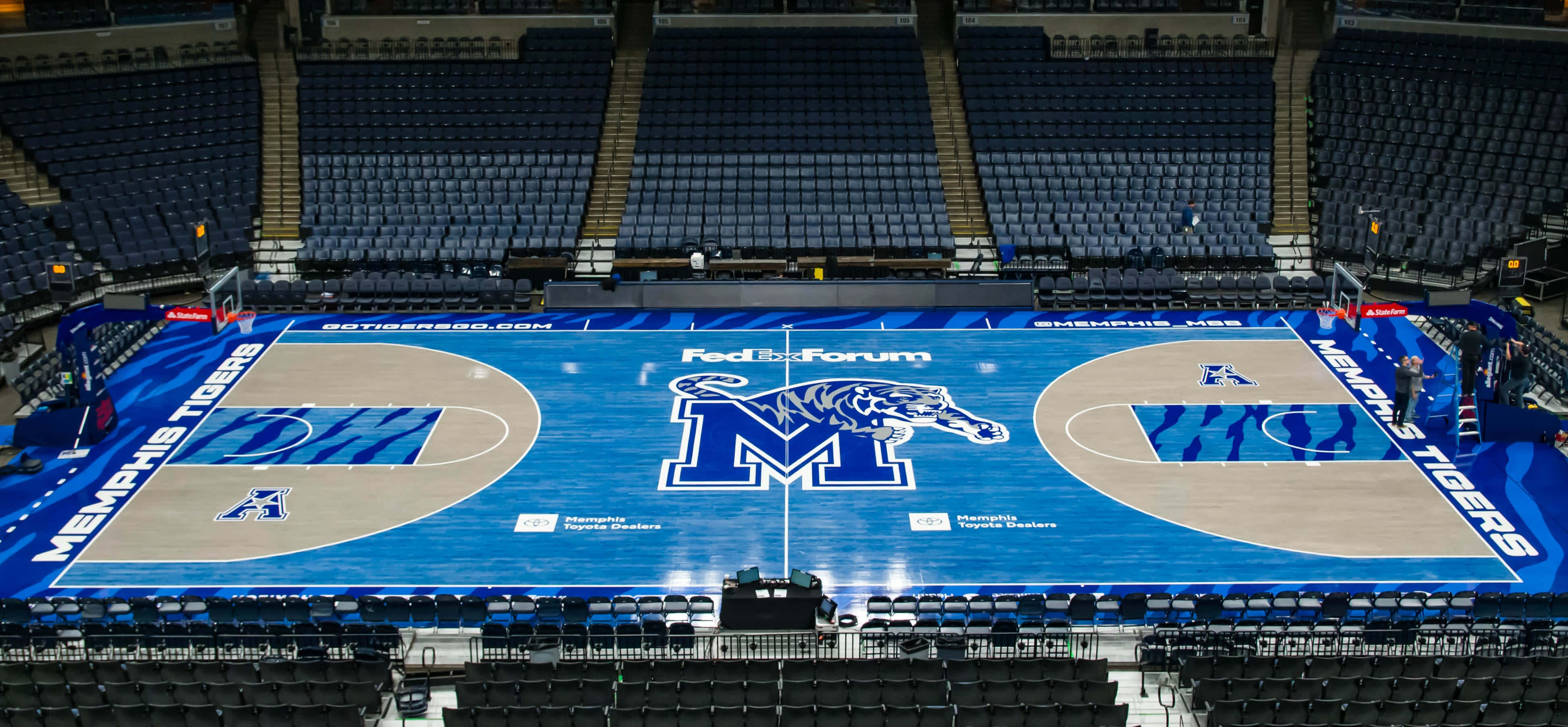 籃球 桌布 壁紙 — FedExForum 內空無一人的孟菲斯老虎隊籃球場的鳥瞰圖，採用藍色和米色設計，周圍是深色座位。