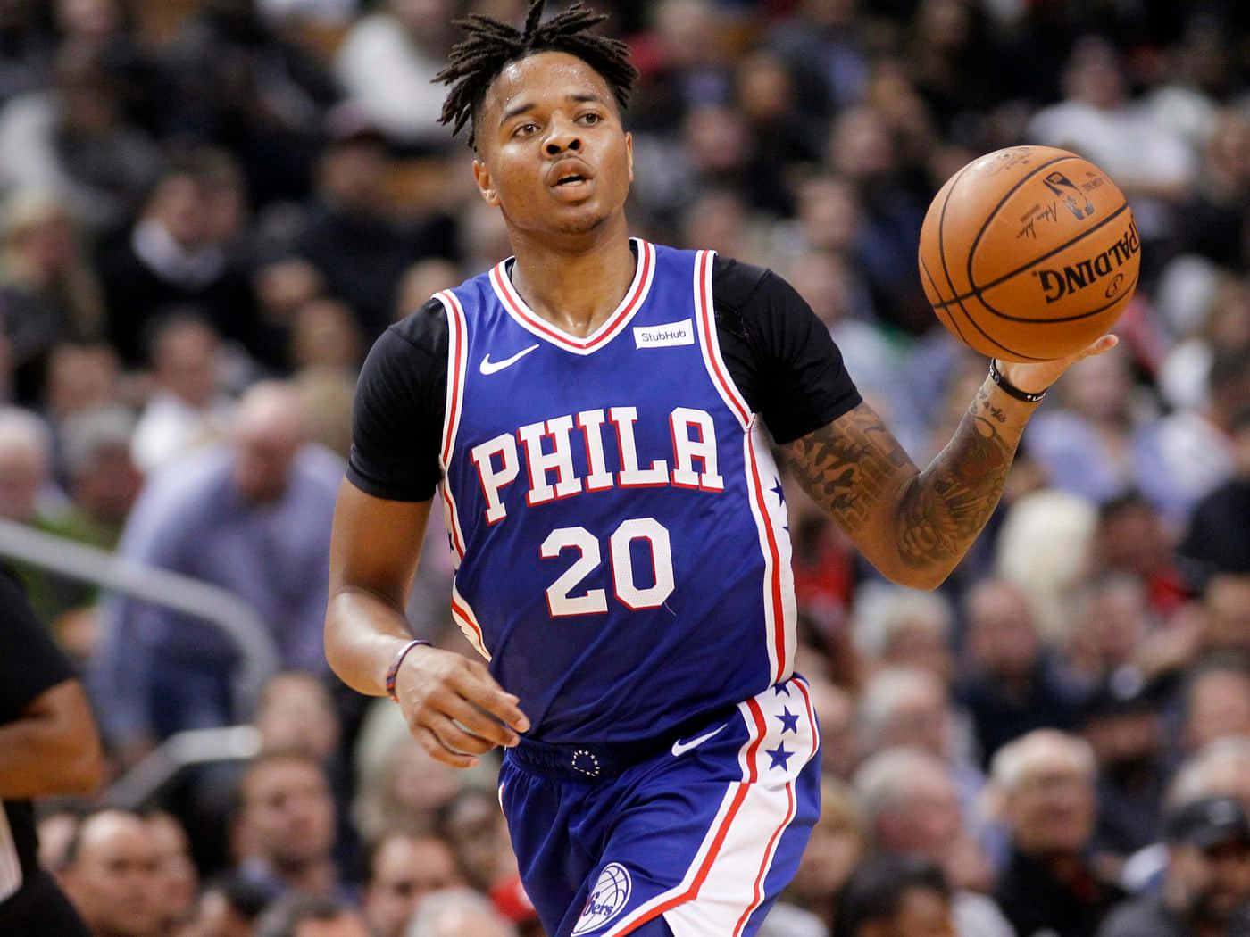 費城76人球員在比賽中運球，背後有觀眾。 — NBA 壁紙