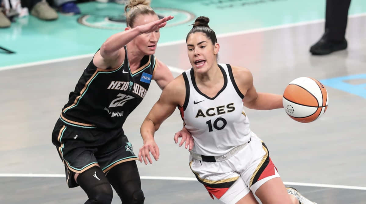  壁紙 — 一位身穿白色「ACES 10」球衣的女籃球員在拋光球場上運球，同時被身穿黑色「FLEET GUARD 22」球衣的對手緊密防守。