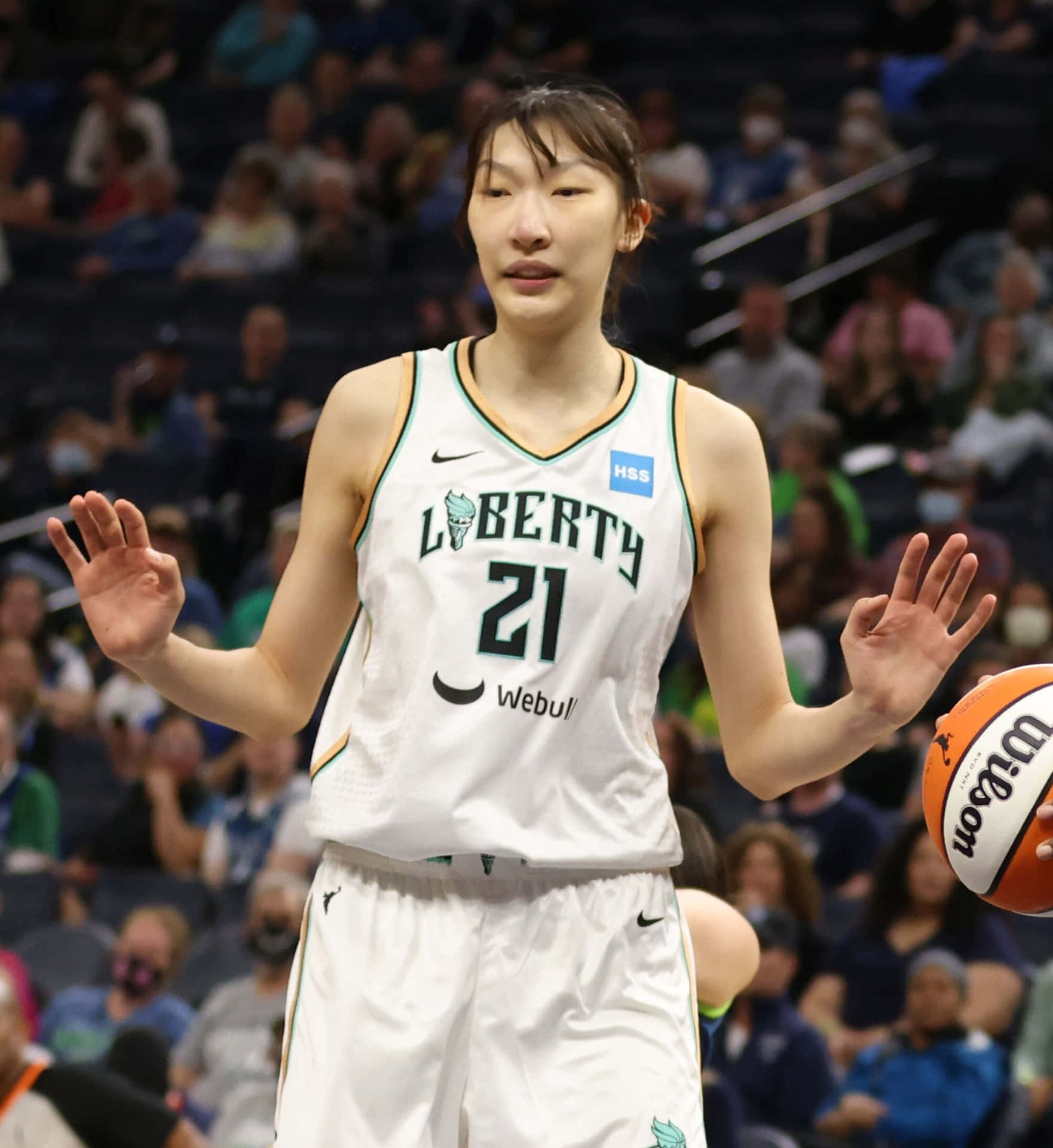 身穿白色自由人隊球衣的女籃球員在比賽中舉手拿球。 — NBA 壁紙