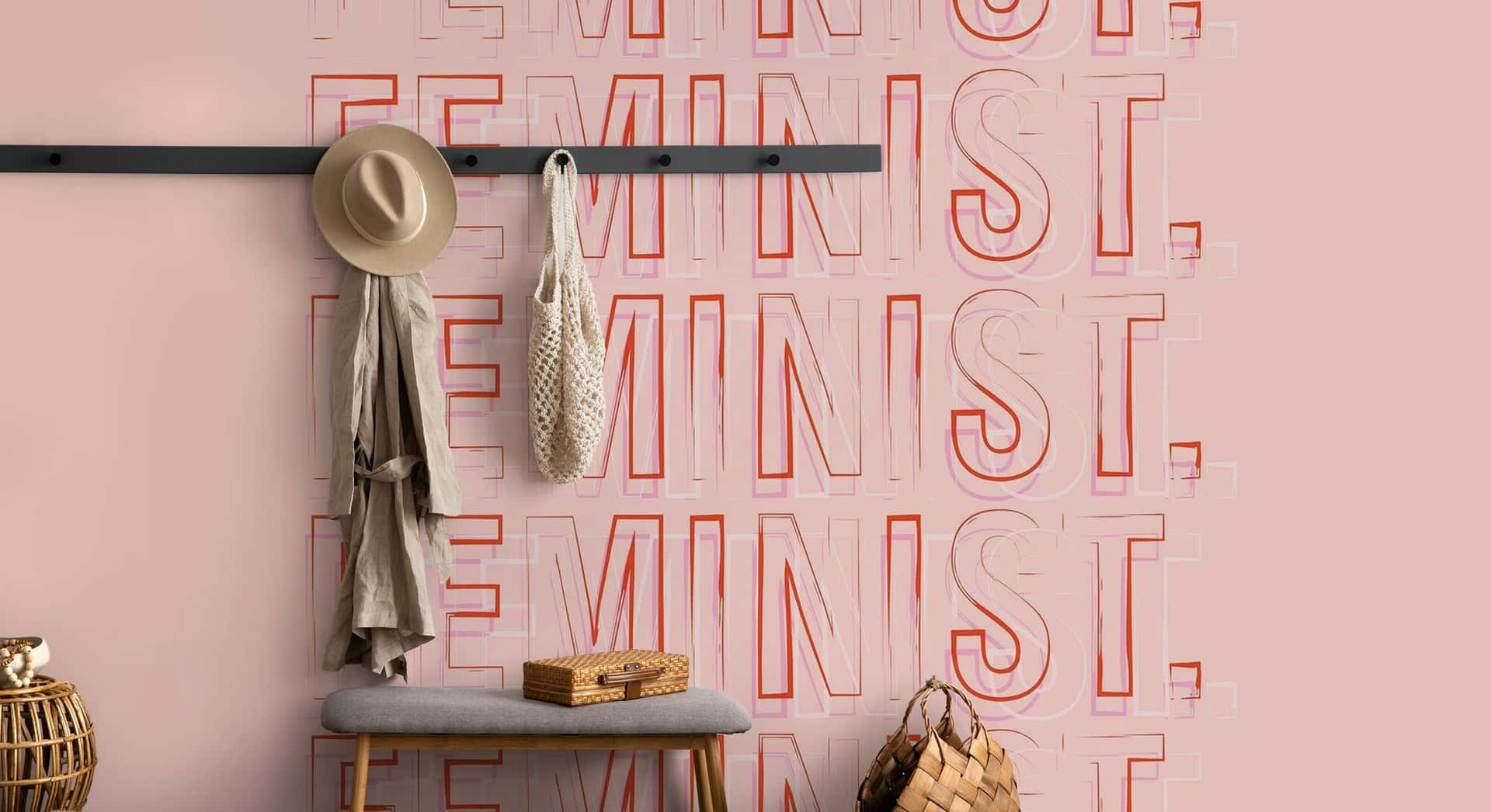  壁紙 — 一面粉紅色牆壁，上面有重複的紅色輪廓 'FEMINIST' 文字，掛著帽子、外套和手提袋，下方是一張木長椅和一個編織籃。